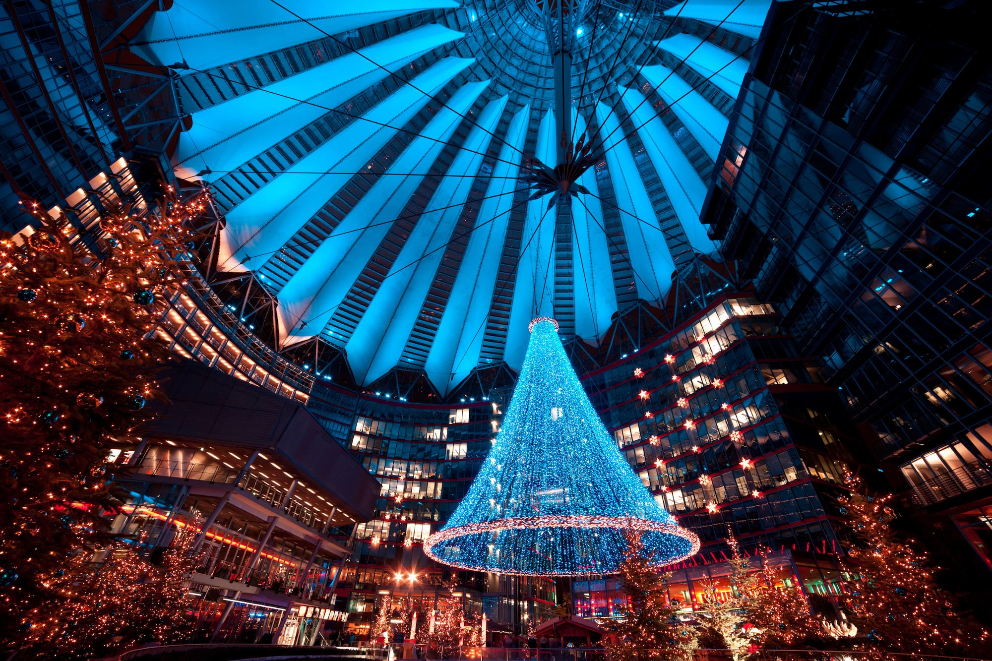 a large blue christmas tree in a large building