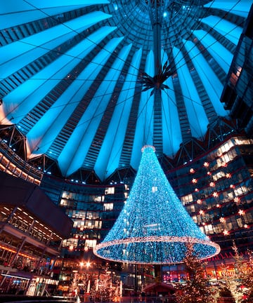 a large blue christmas tree in a large building