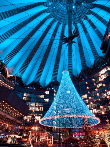 a large blue christmas tree in a large building
