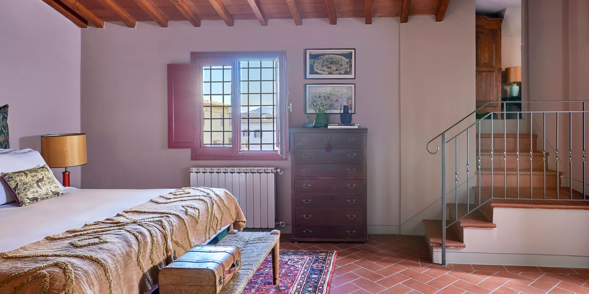 a room with a bed and a rug and a staircase