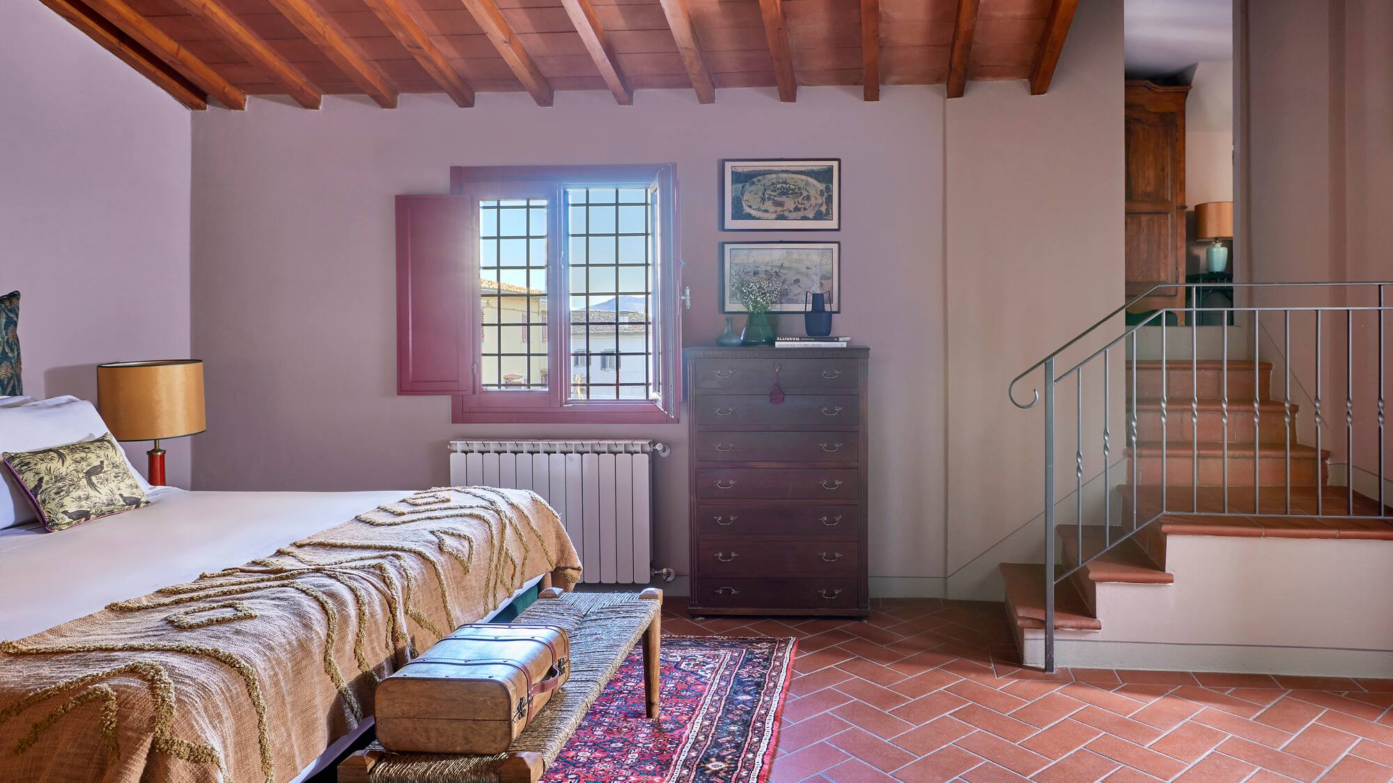 a room with a bed and a rug and a staircase