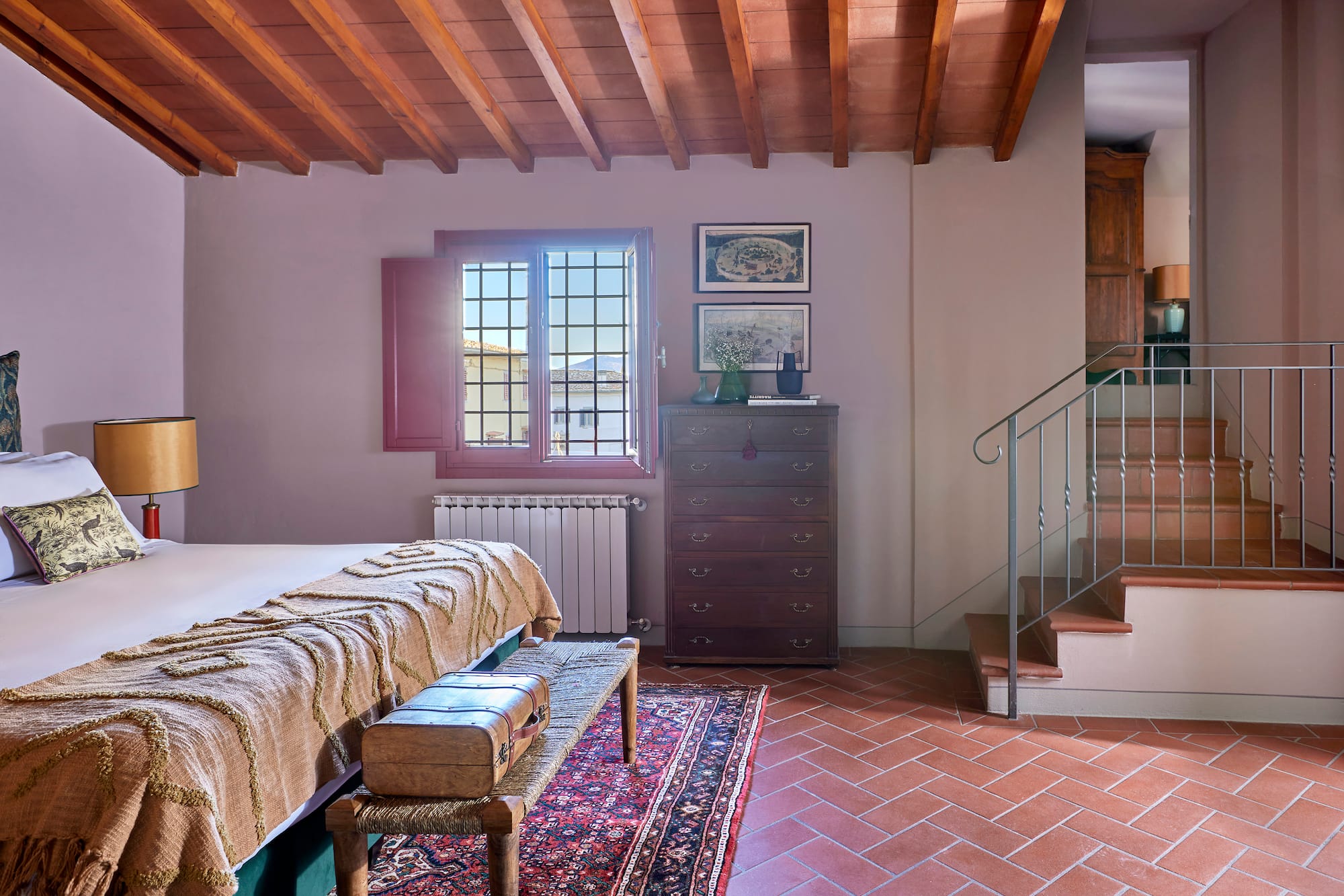 a room with a bed and a rug and a staircase