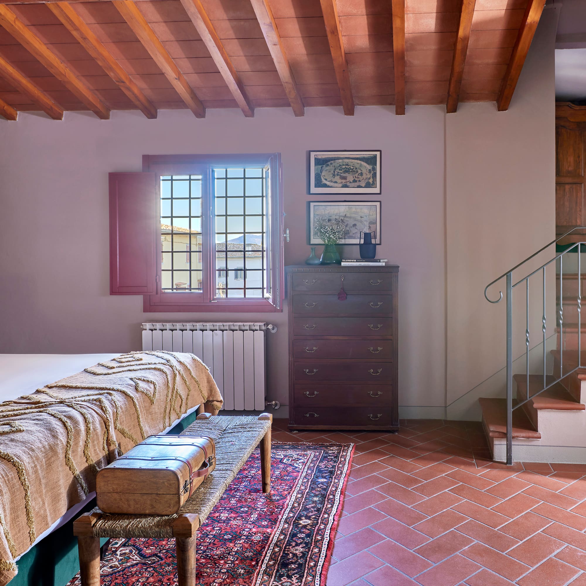 a room with a bed and a rug and a staircase