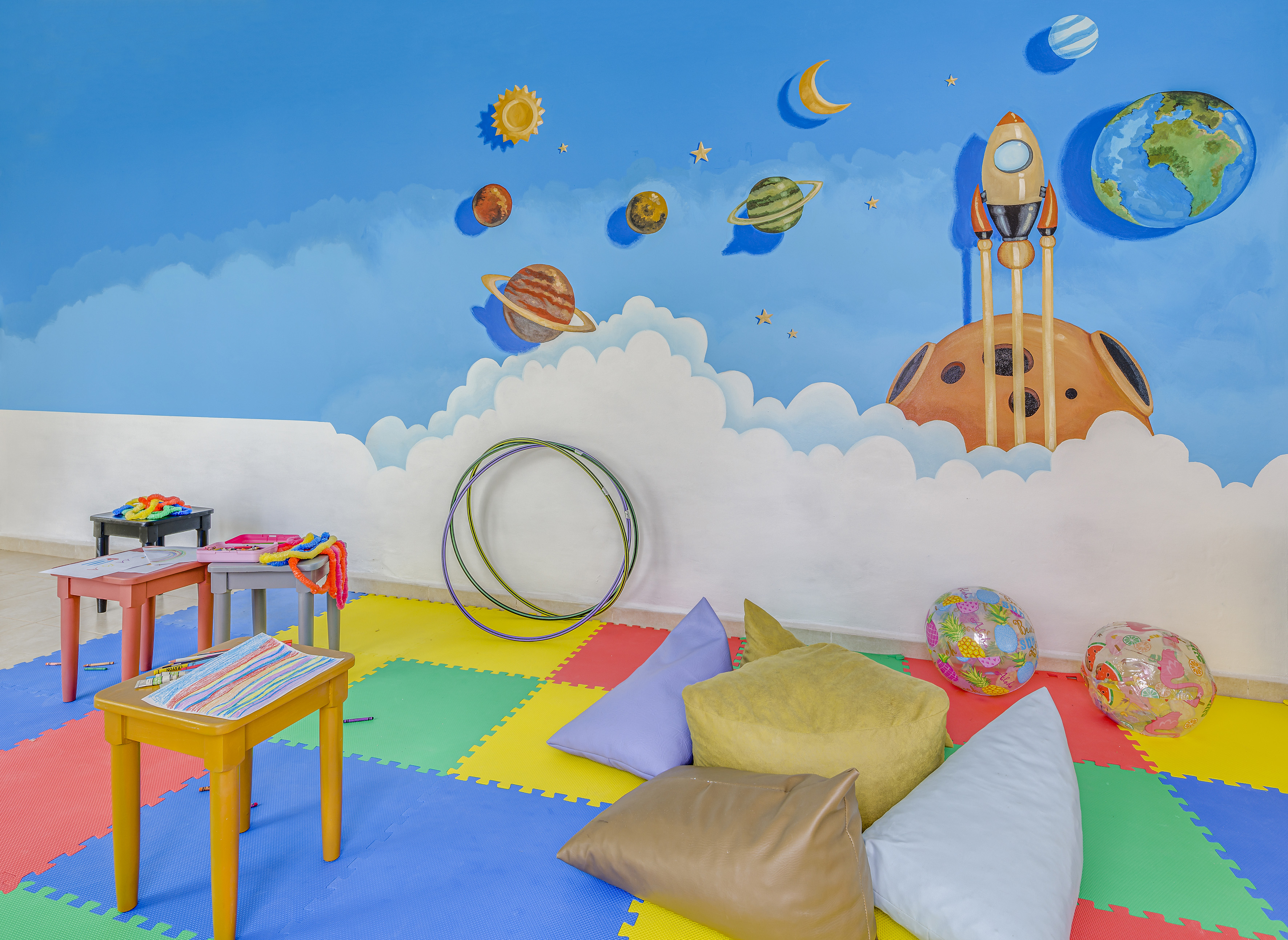 a room with a mural of planets and a rocket