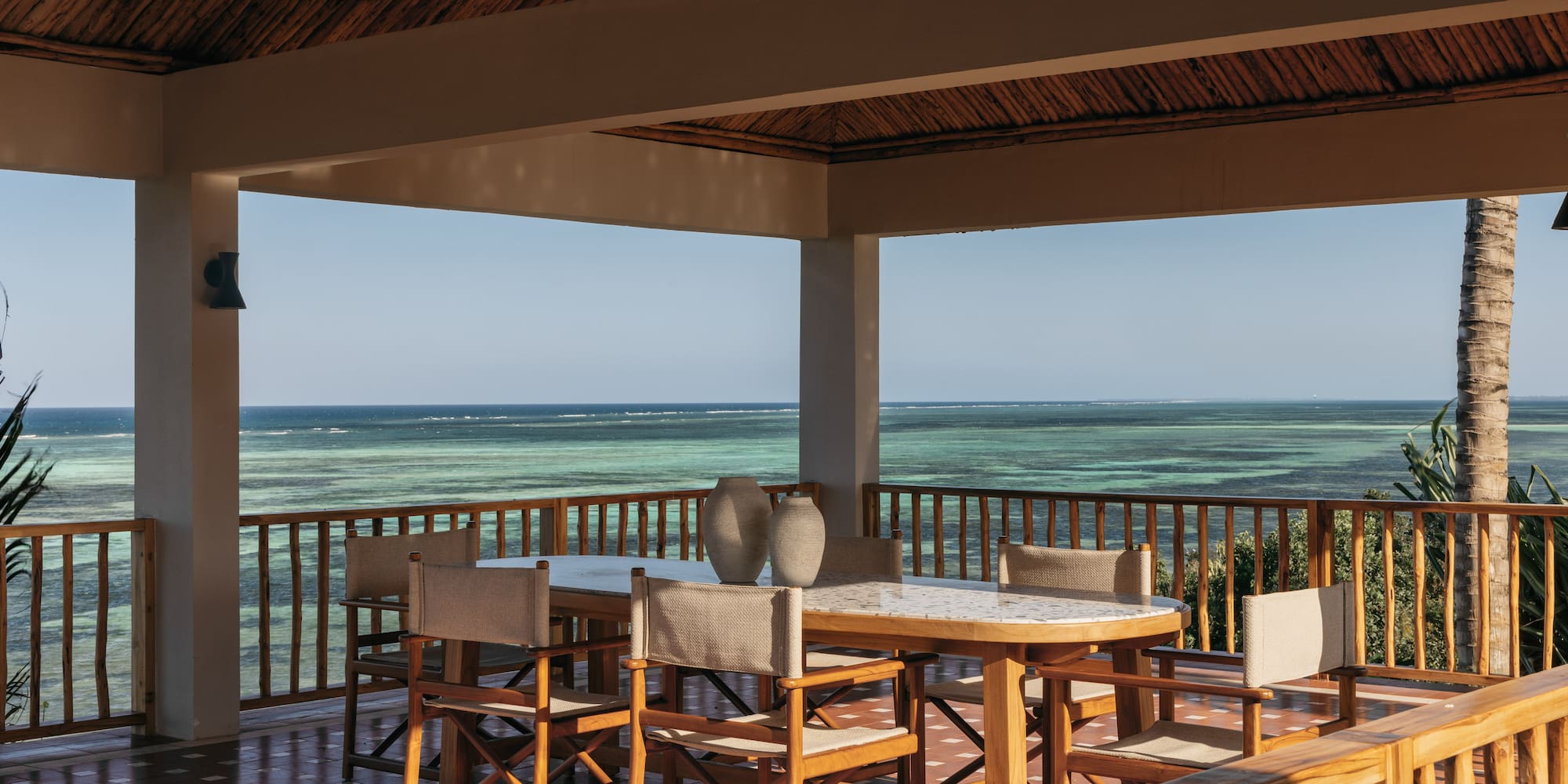 a table and chairs on a deck overlooking the ocean