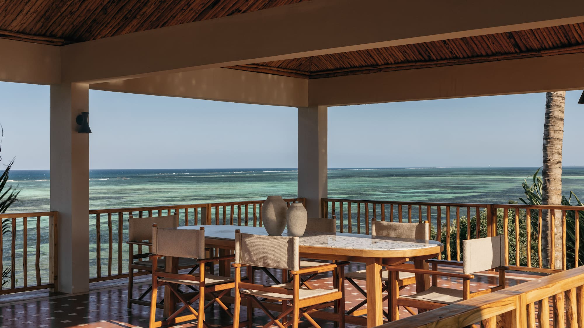 a table and chairs on a deck overlooking the ocean