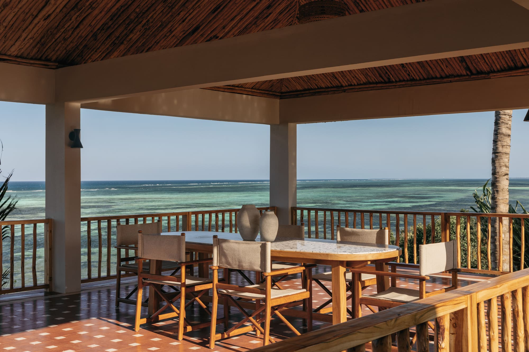 a table and chairs on a deck overlooking the ocean