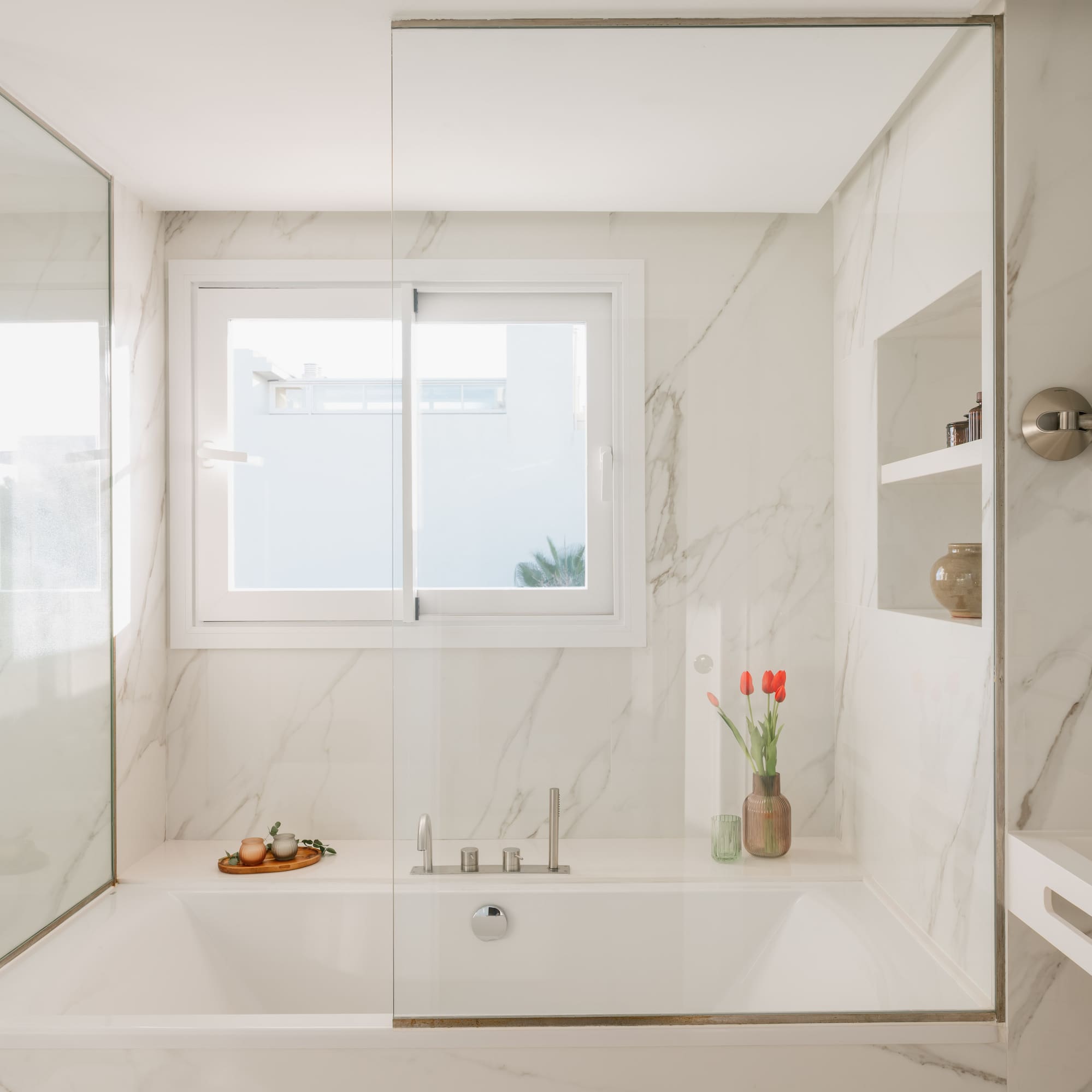 a white bathtub with glass doors