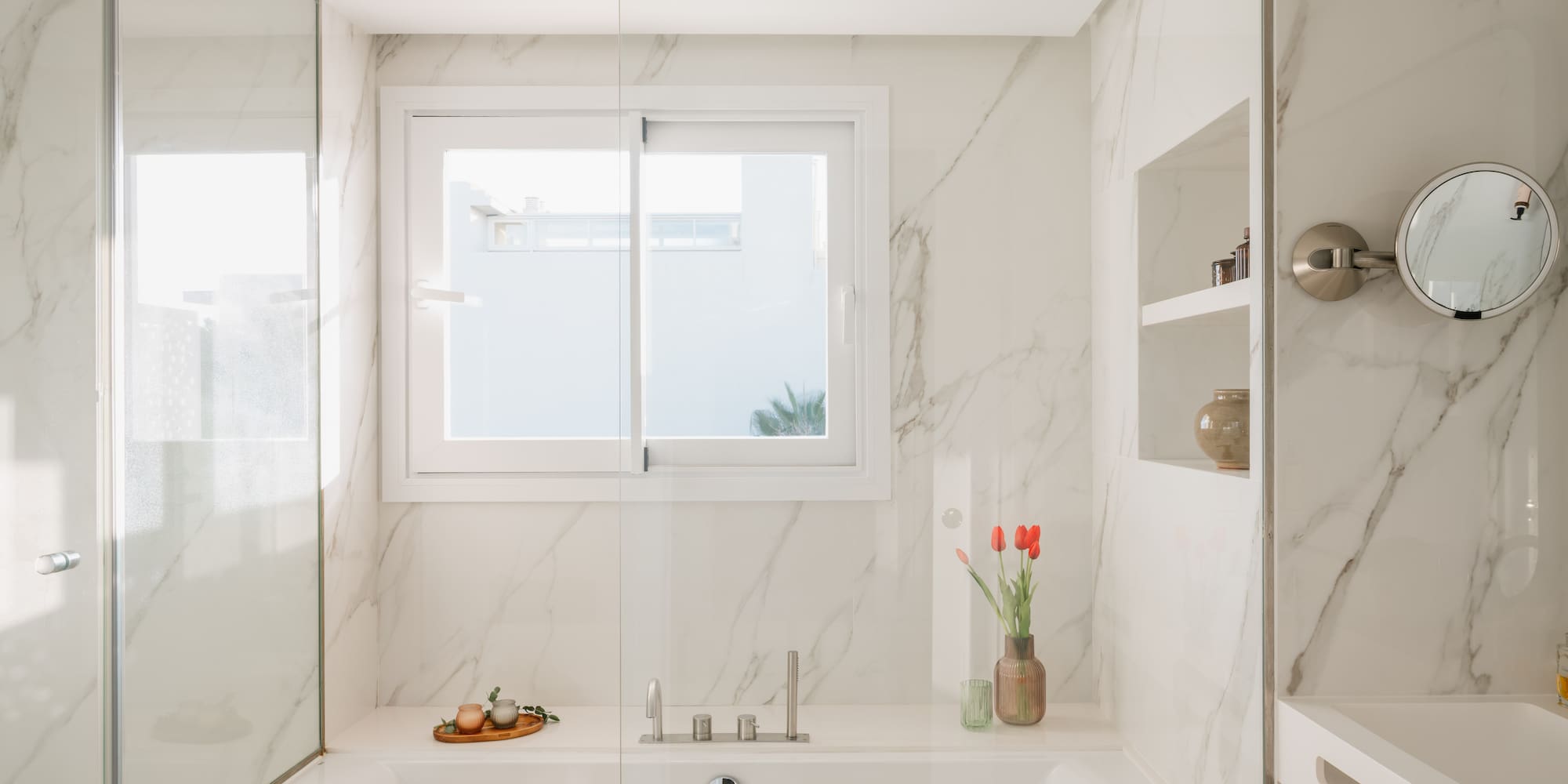 a white bathtub with glass doors