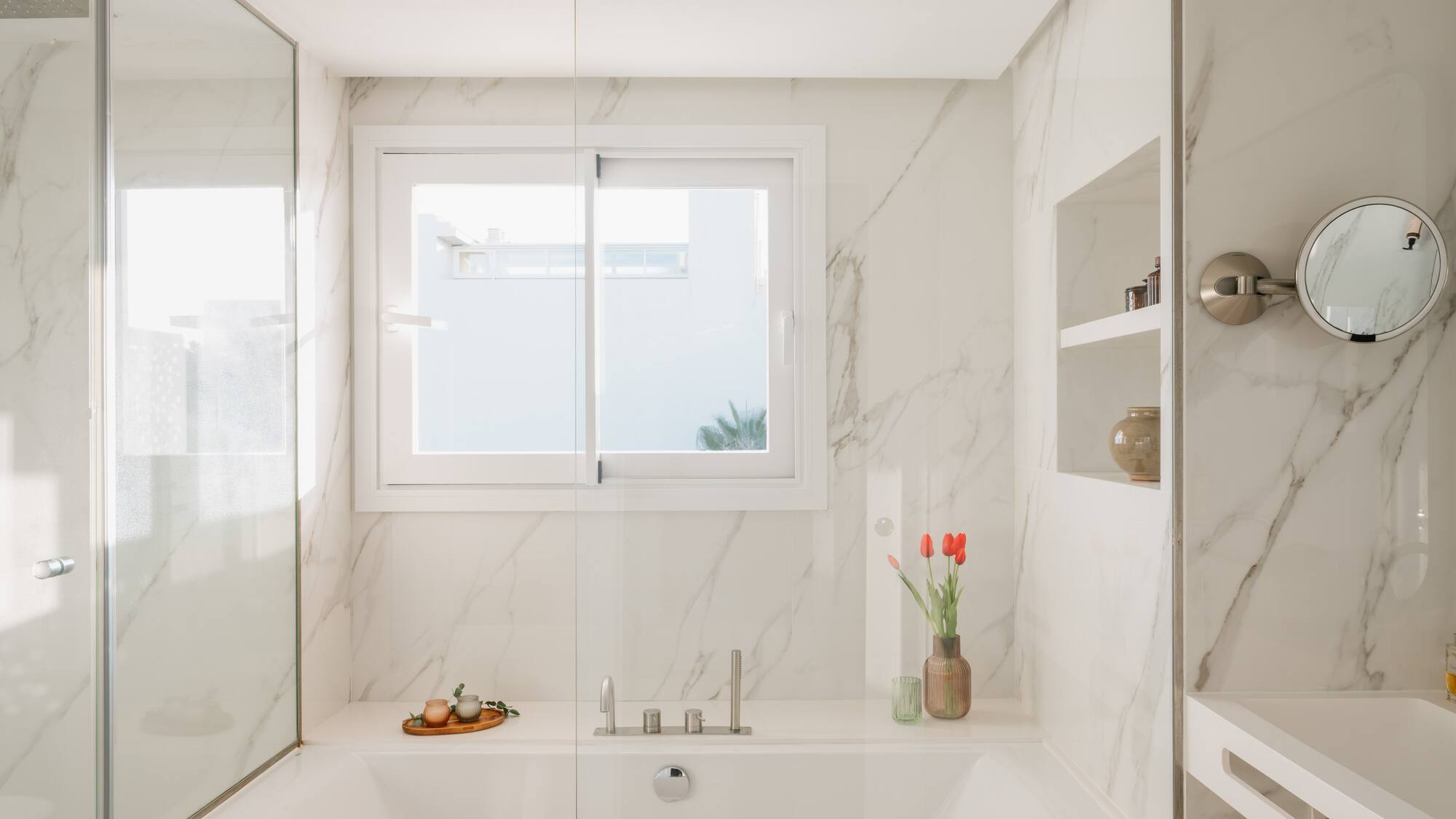 a white bathtub with glass doors