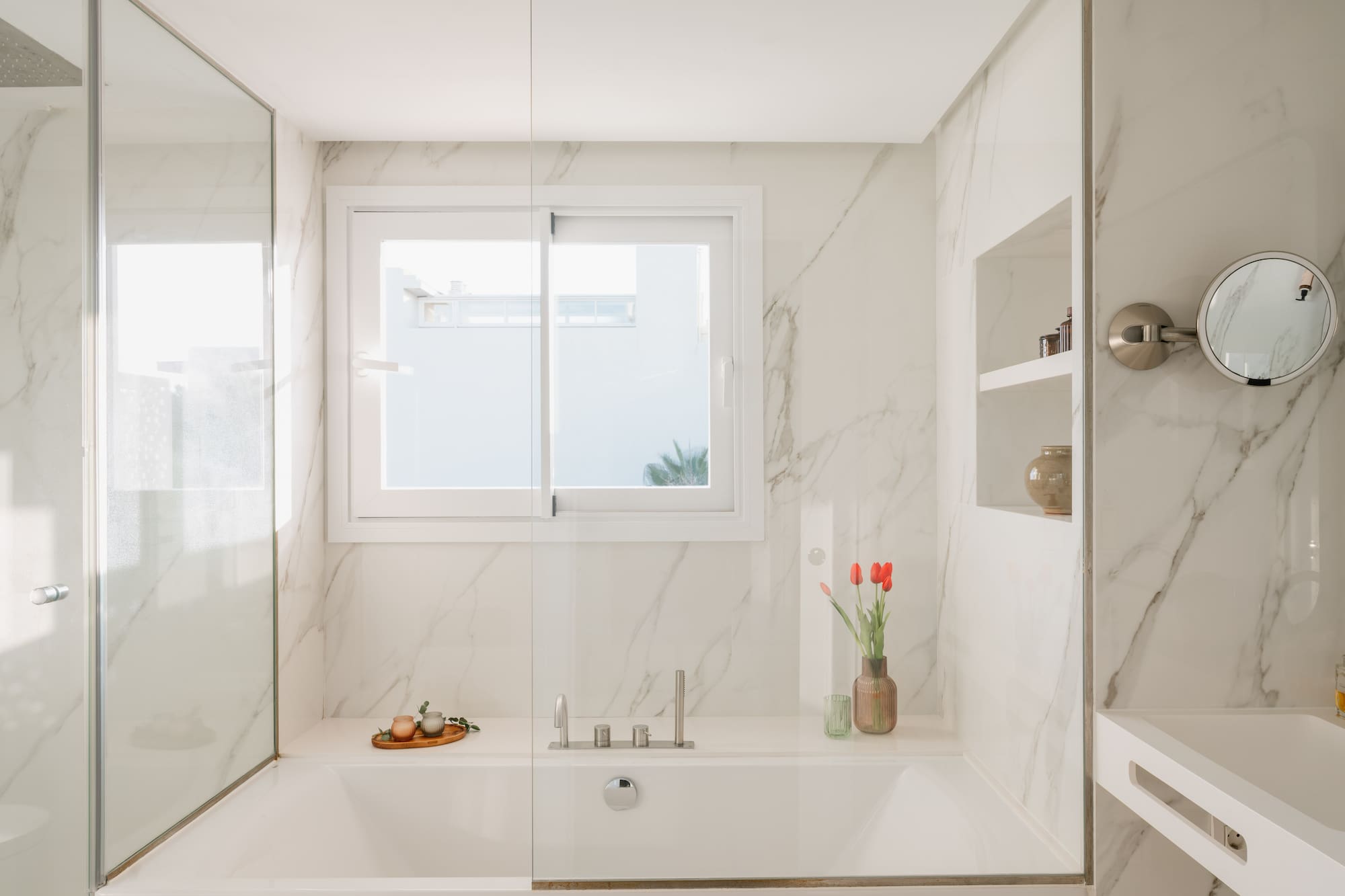 a white bathtub with glass doors