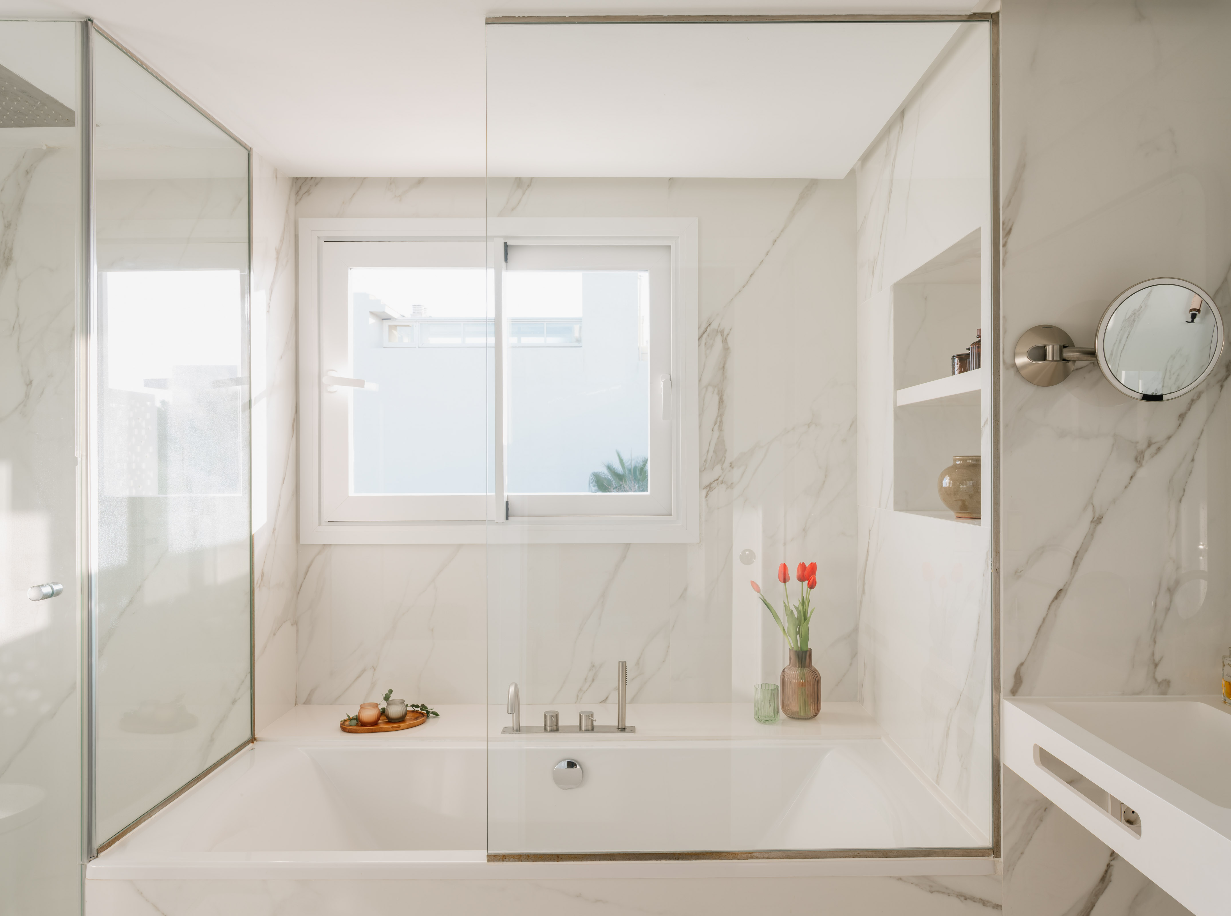 a white bathtub with glass doors