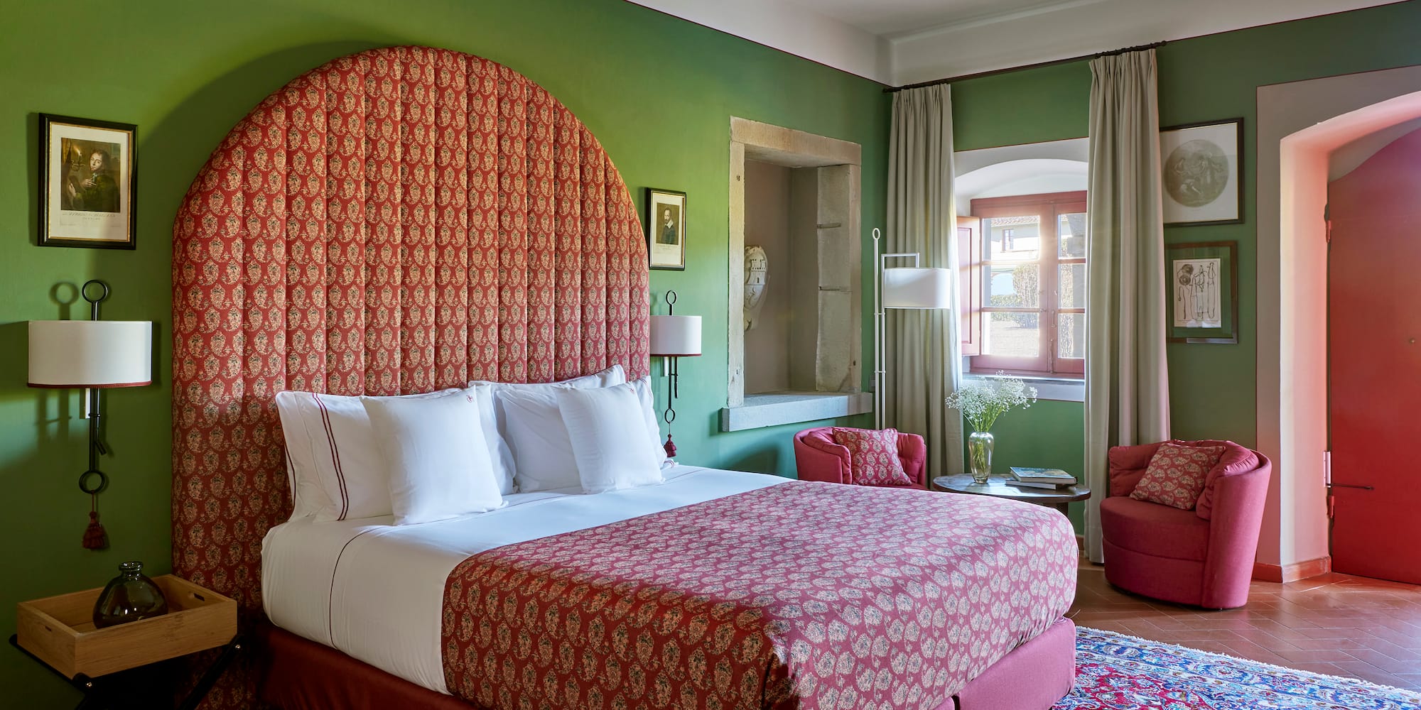 a room with a bed and chairs