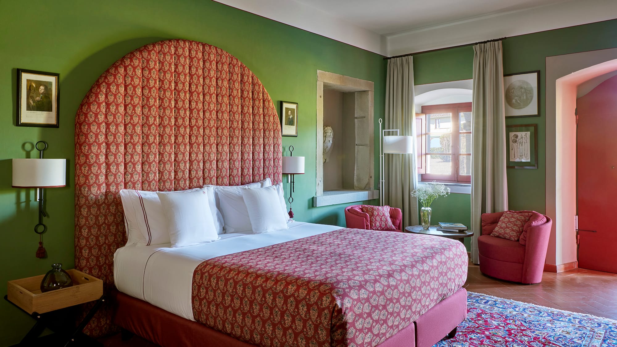 a room with a bed and chairs