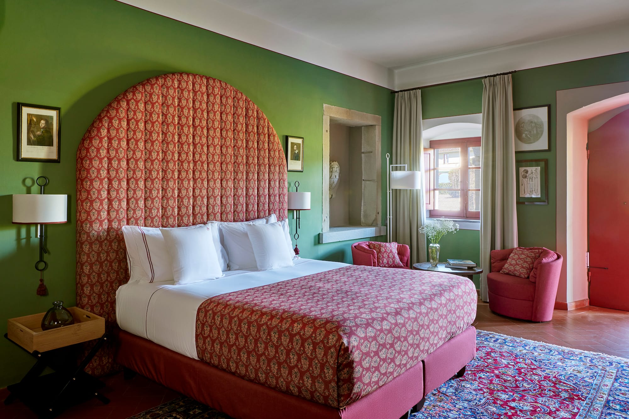 a room with a bed and chairs