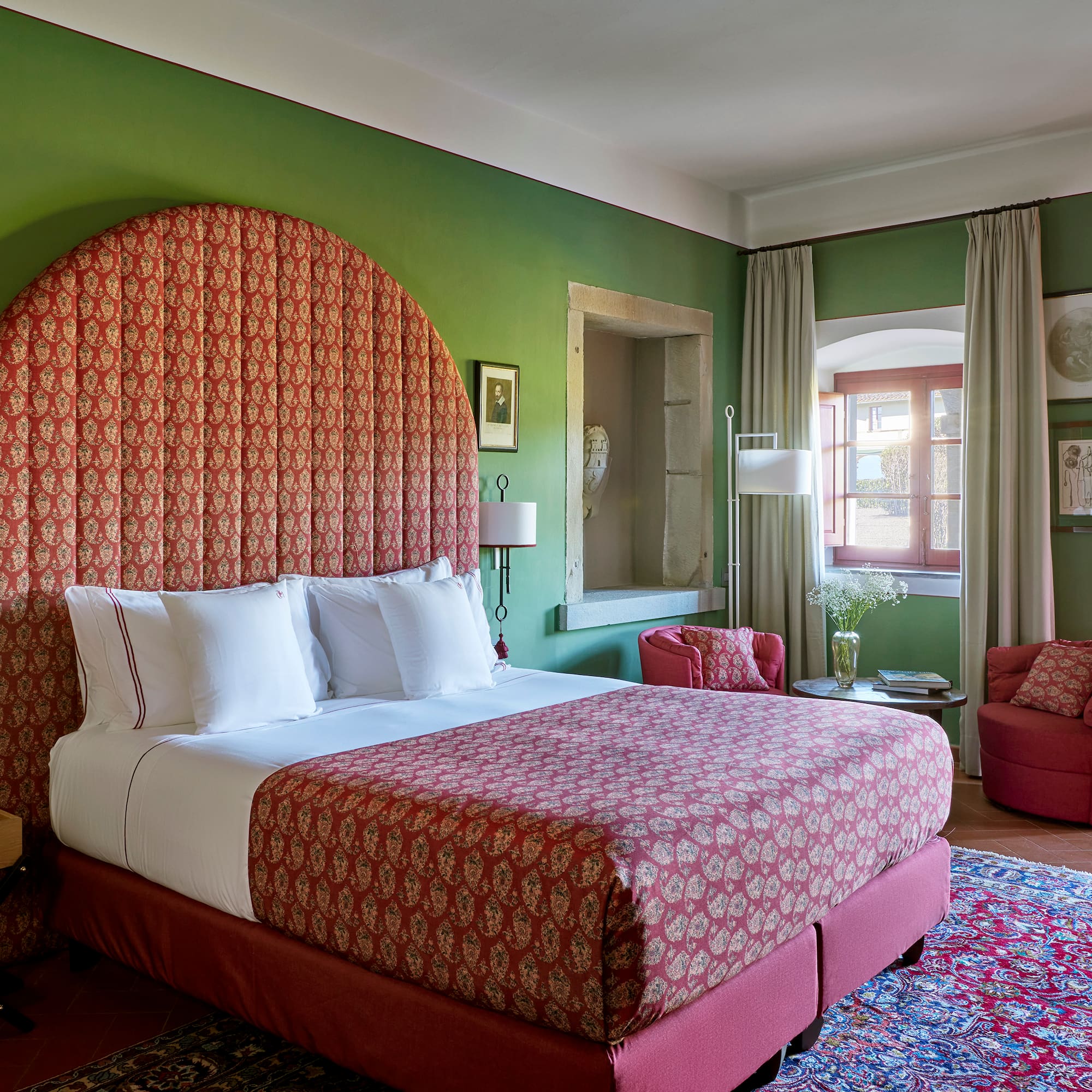 a room with a bed and chairs