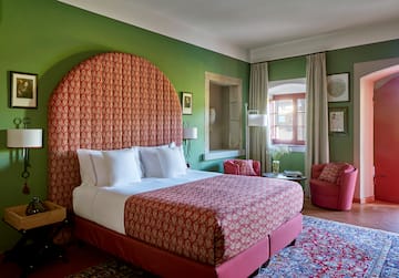 a room with a bed and chairs