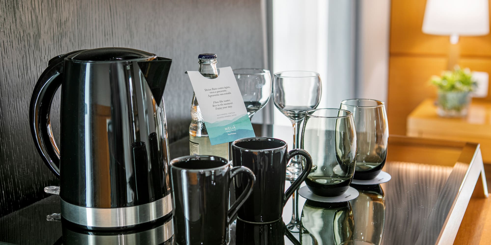 a group of glasses and a kettle on a table