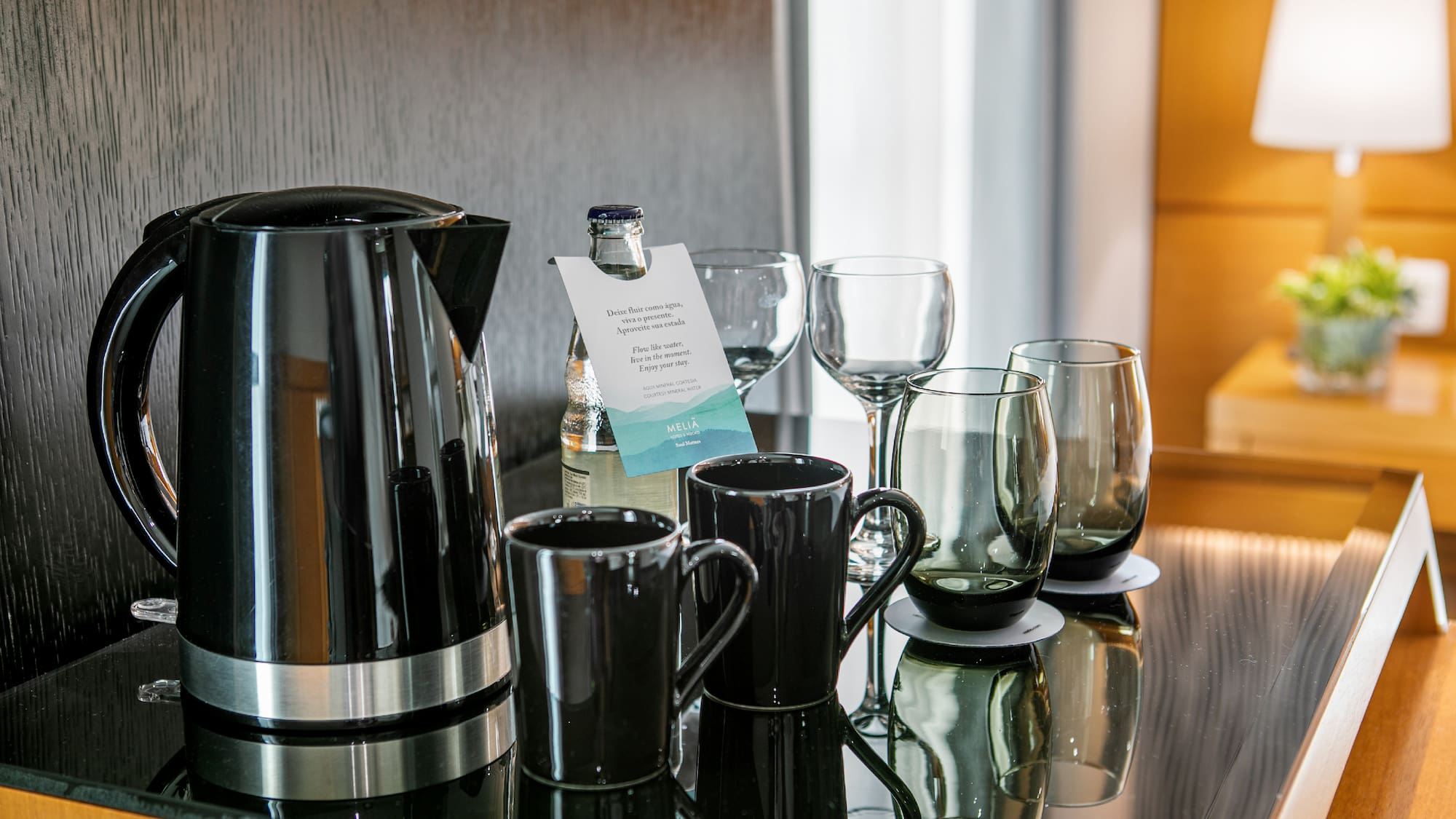 a group of glasses and a kettle on a table
