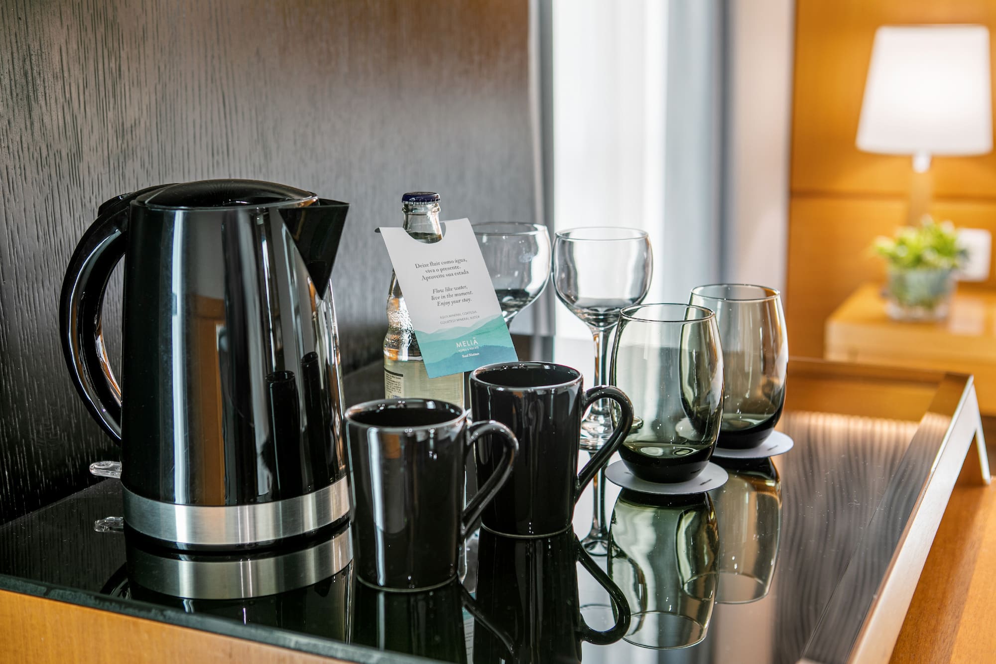 a group of glasses and a kettle on a table