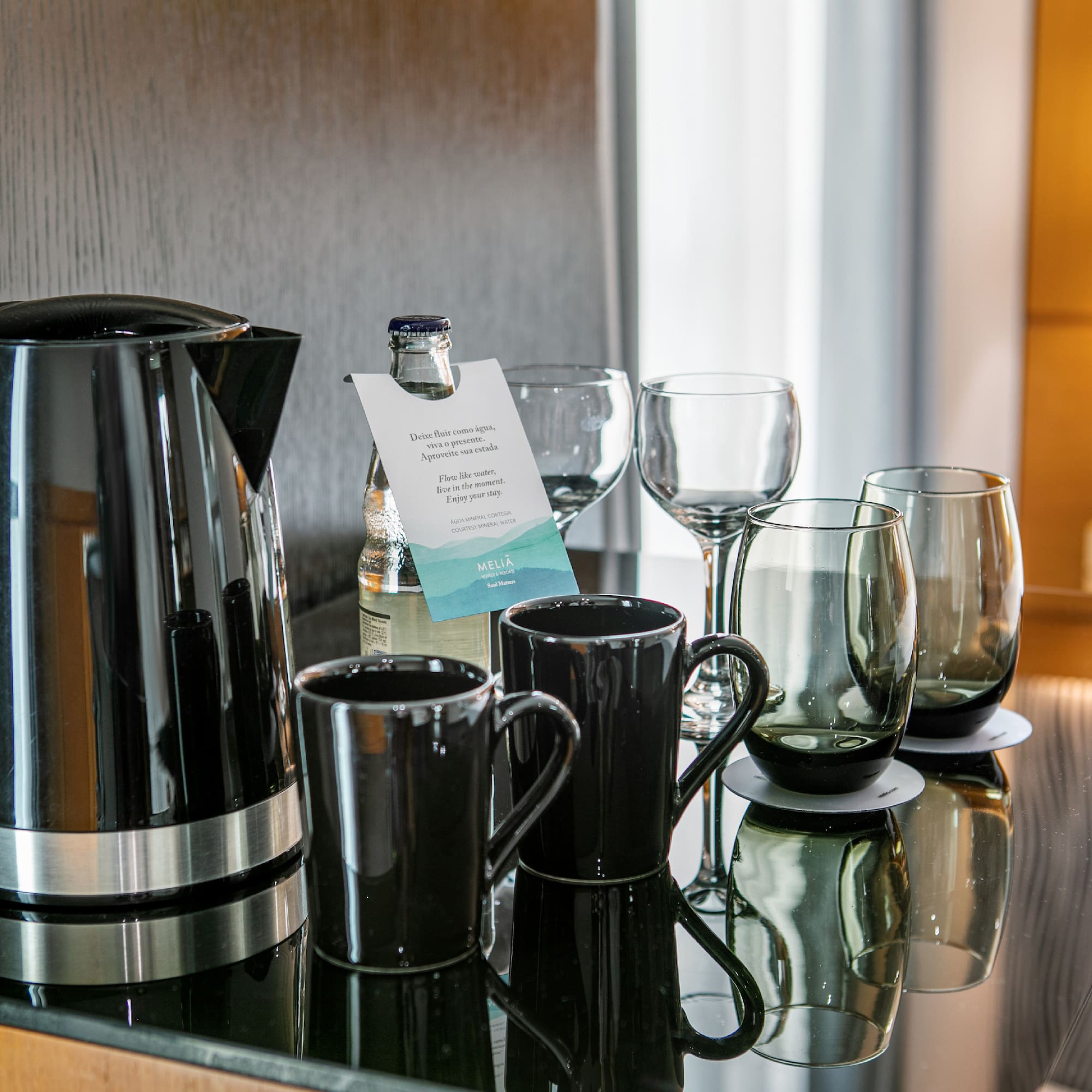 a group of glasses and a kettle on a table