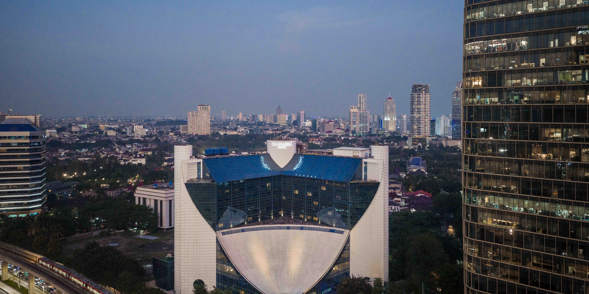 a large building with a curved roof and a city skyline