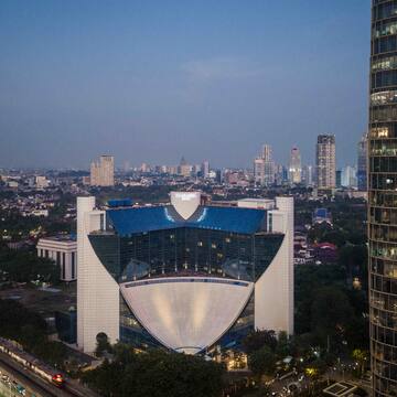 a large building with a curved roof and a city skyline
