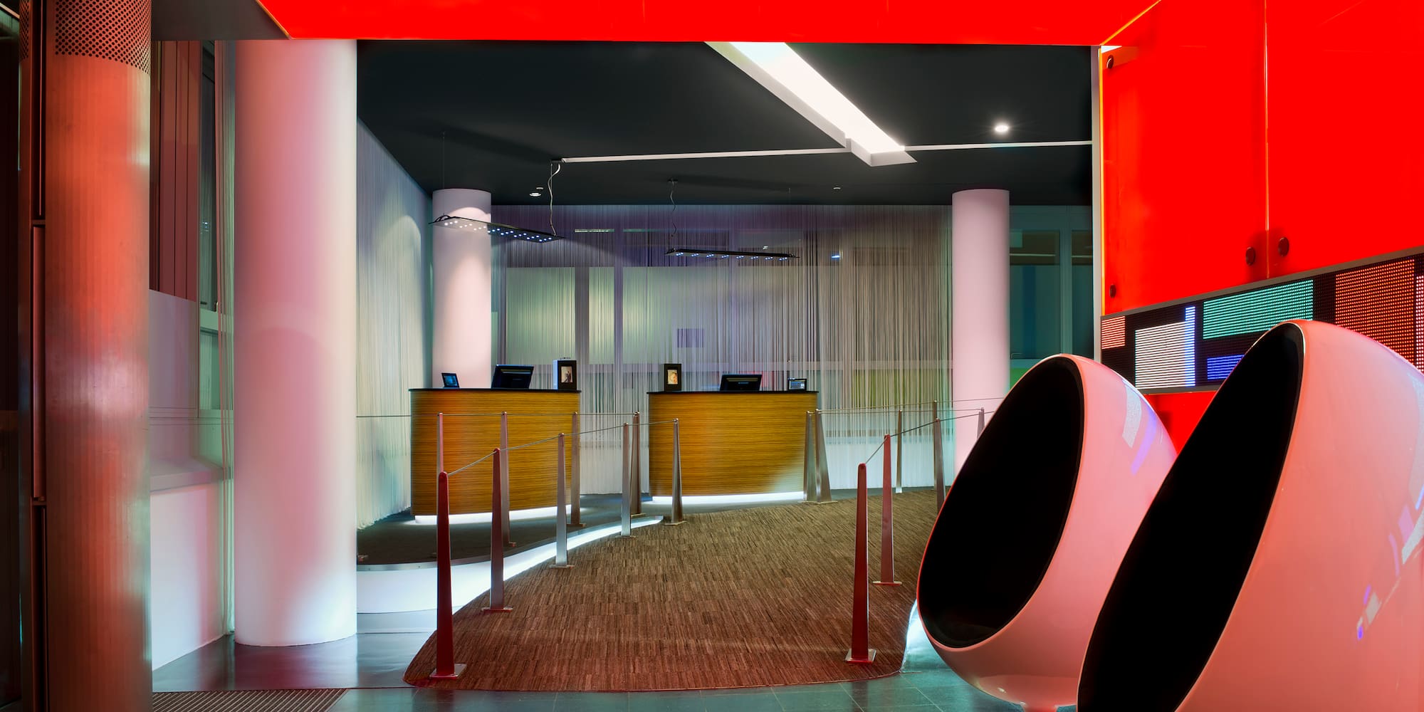 a lobby with red walls and white columns