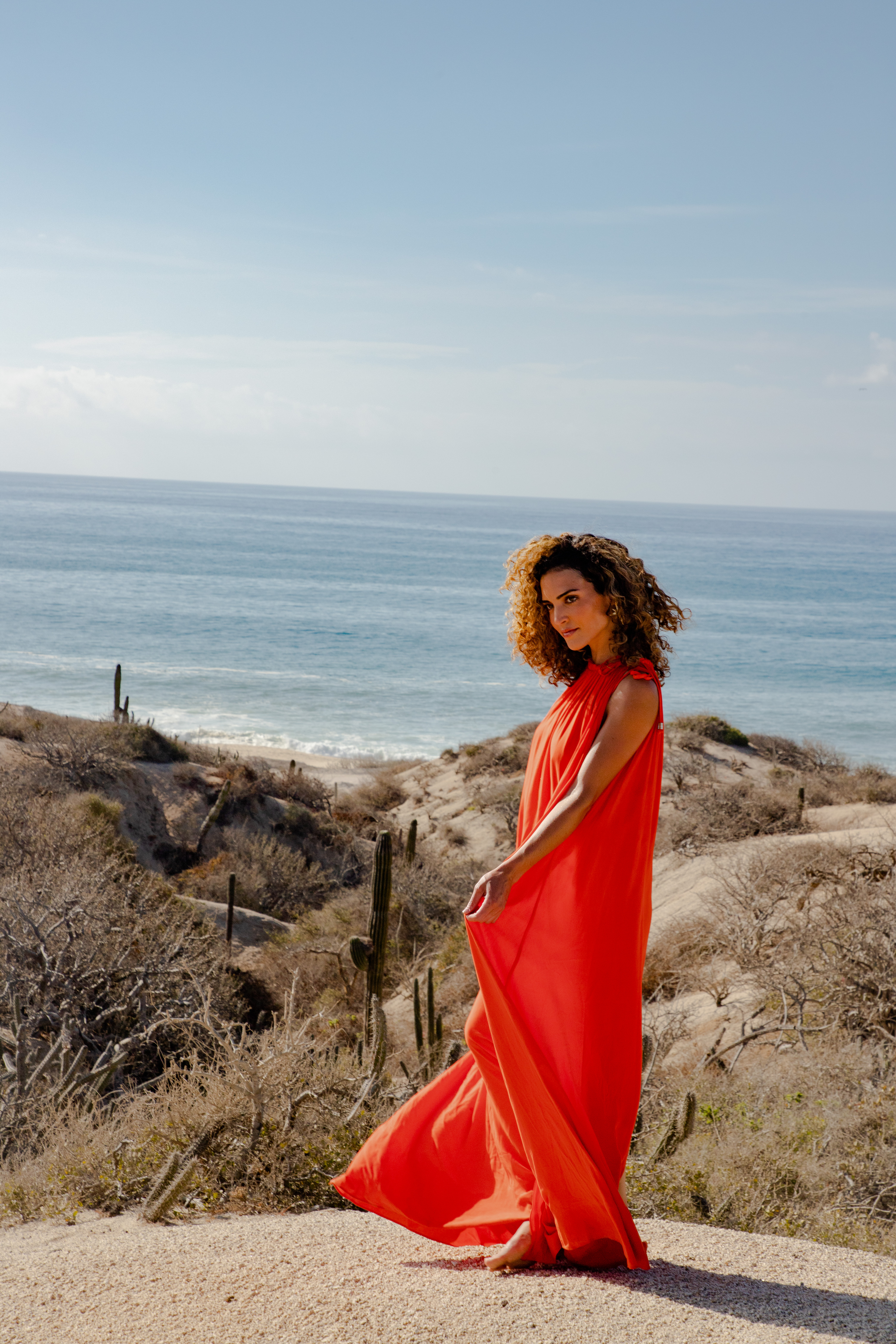 a woman in a red dress on a beach