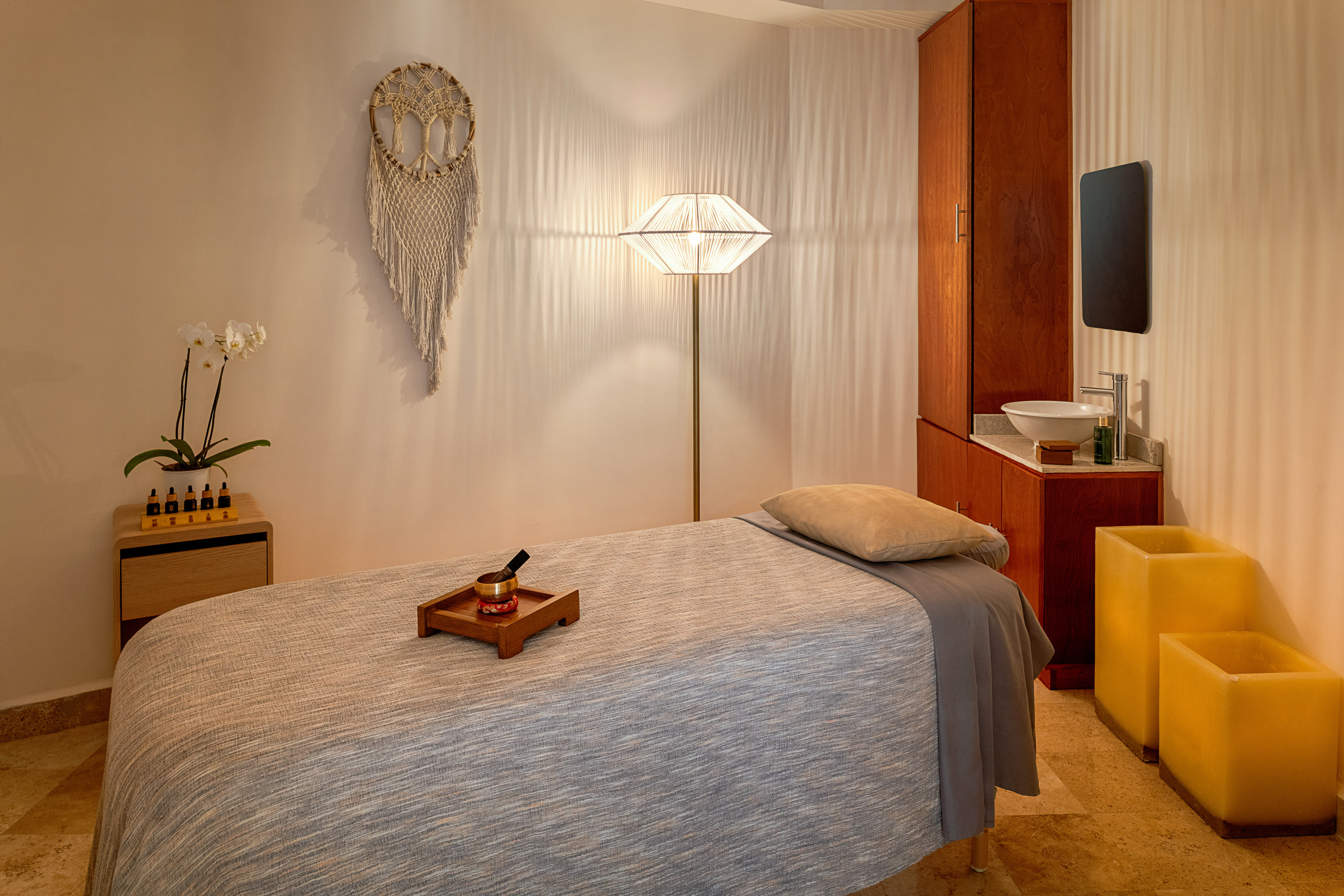 Calm spa massage room with treatment bed, essential oils, and soft lighting.