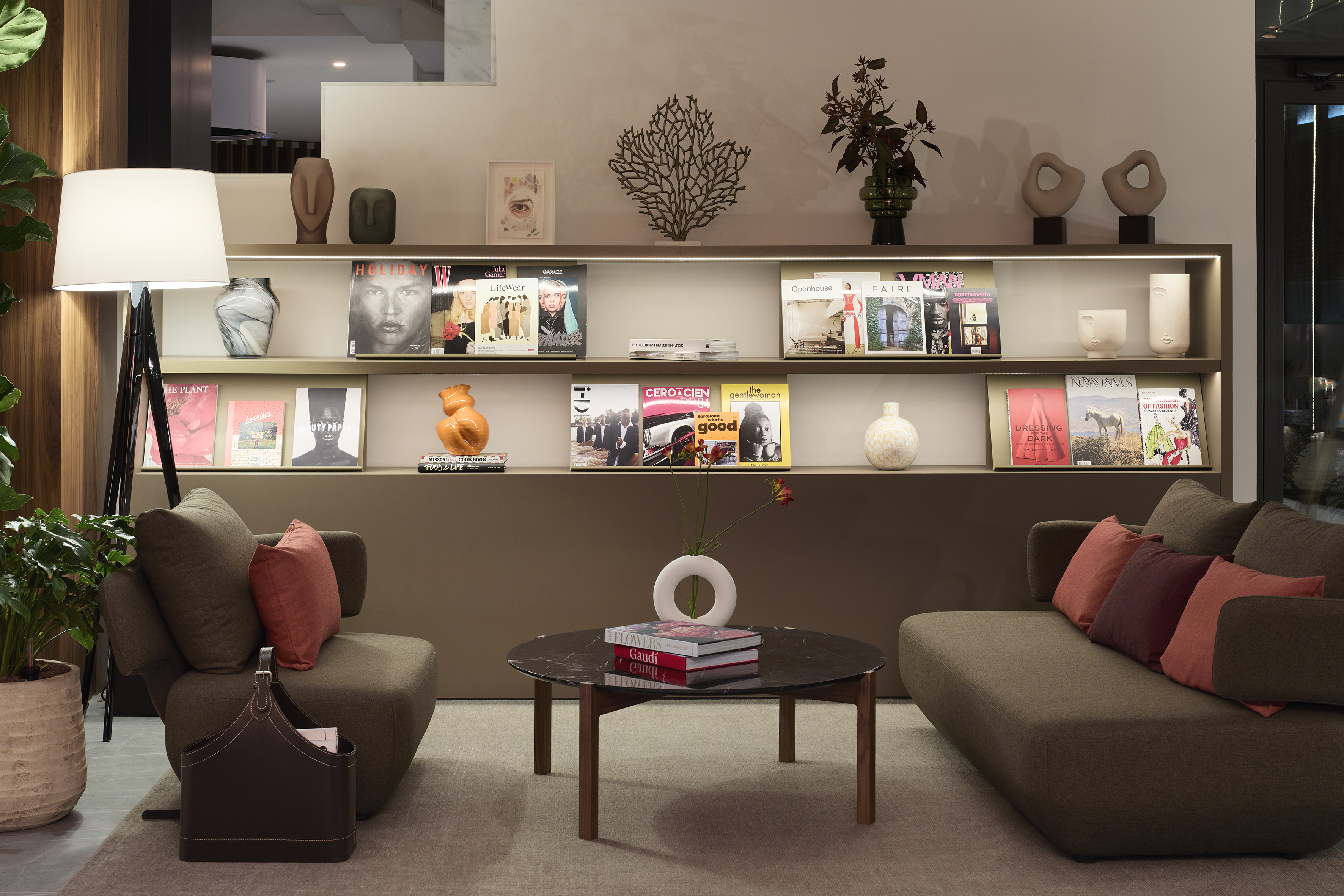 Modern lounge with brown seating, coffee table, and stylish illuminated shelves.