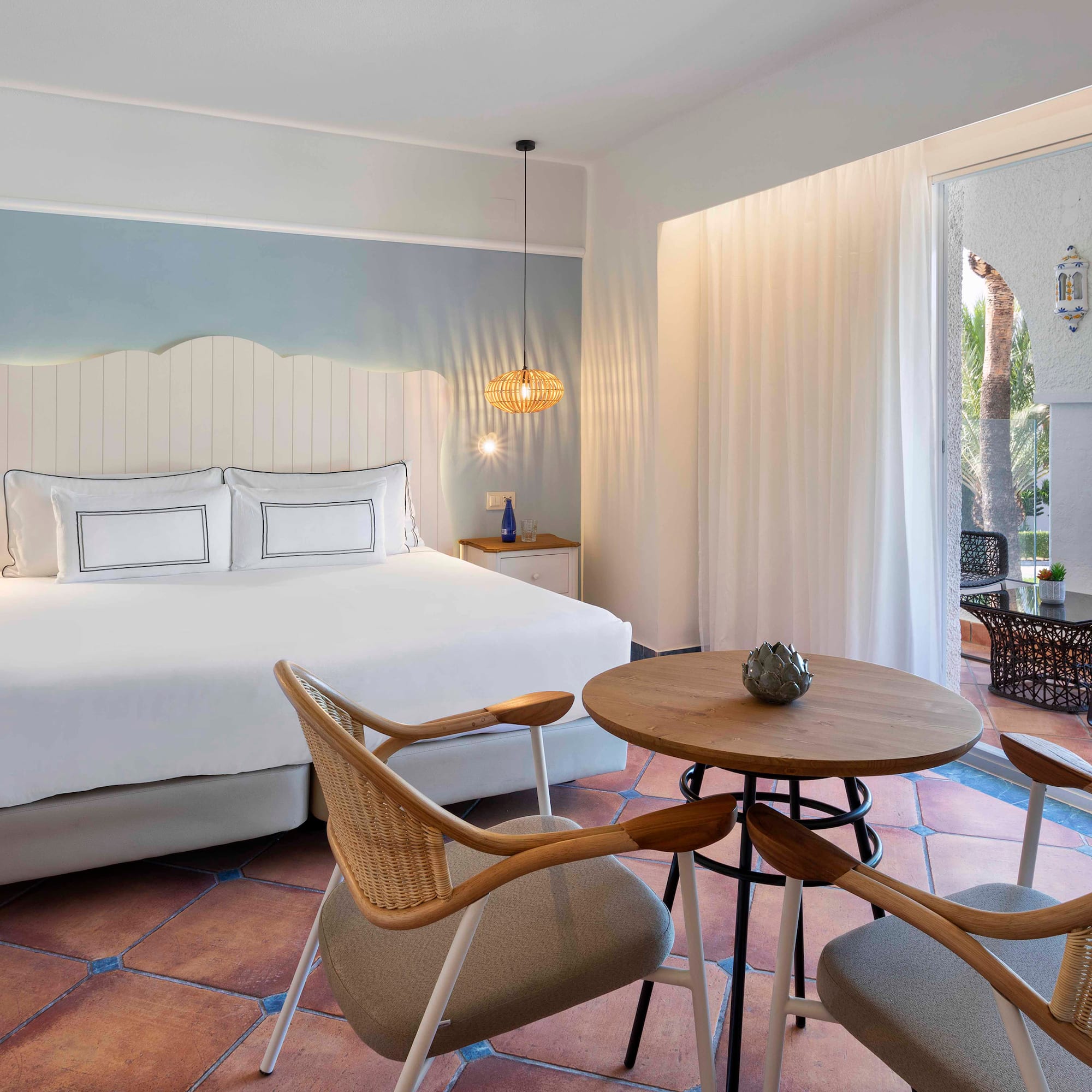 a room with a bed and chairs