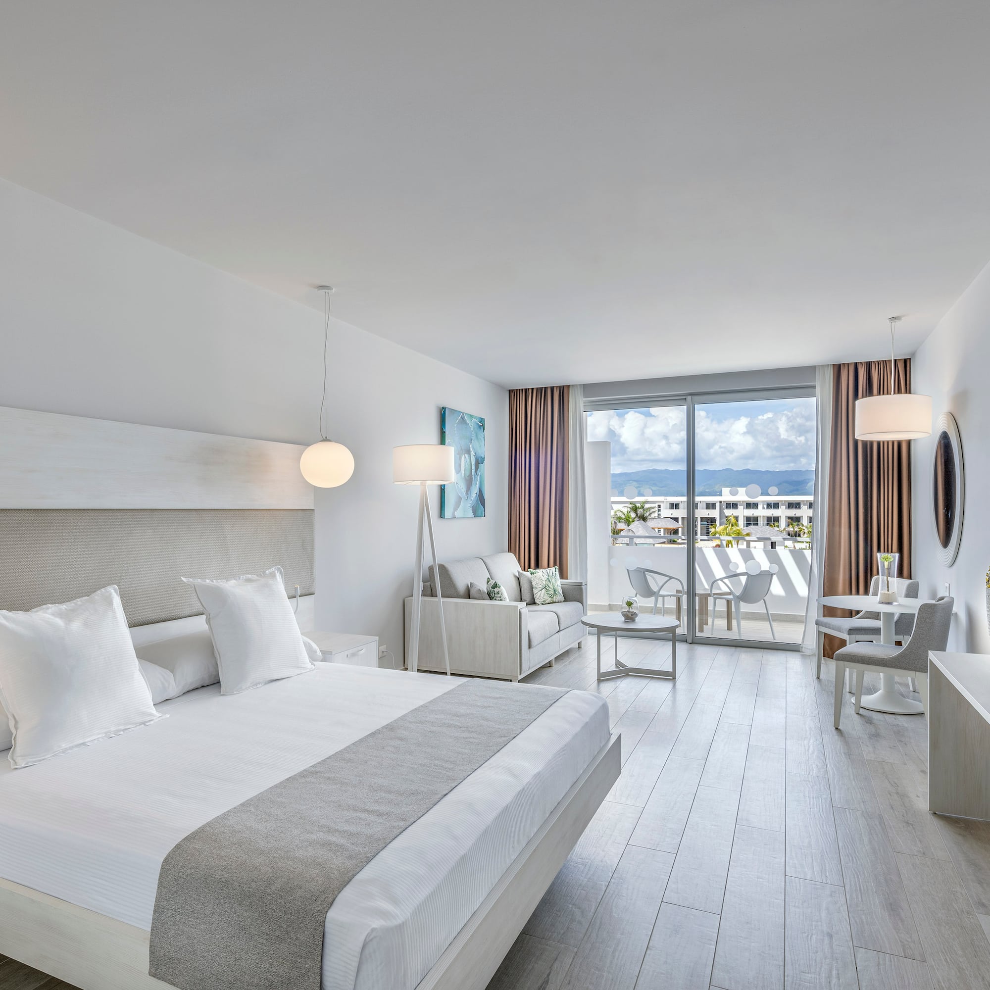 a bedroom with a large bed and a table and chairs