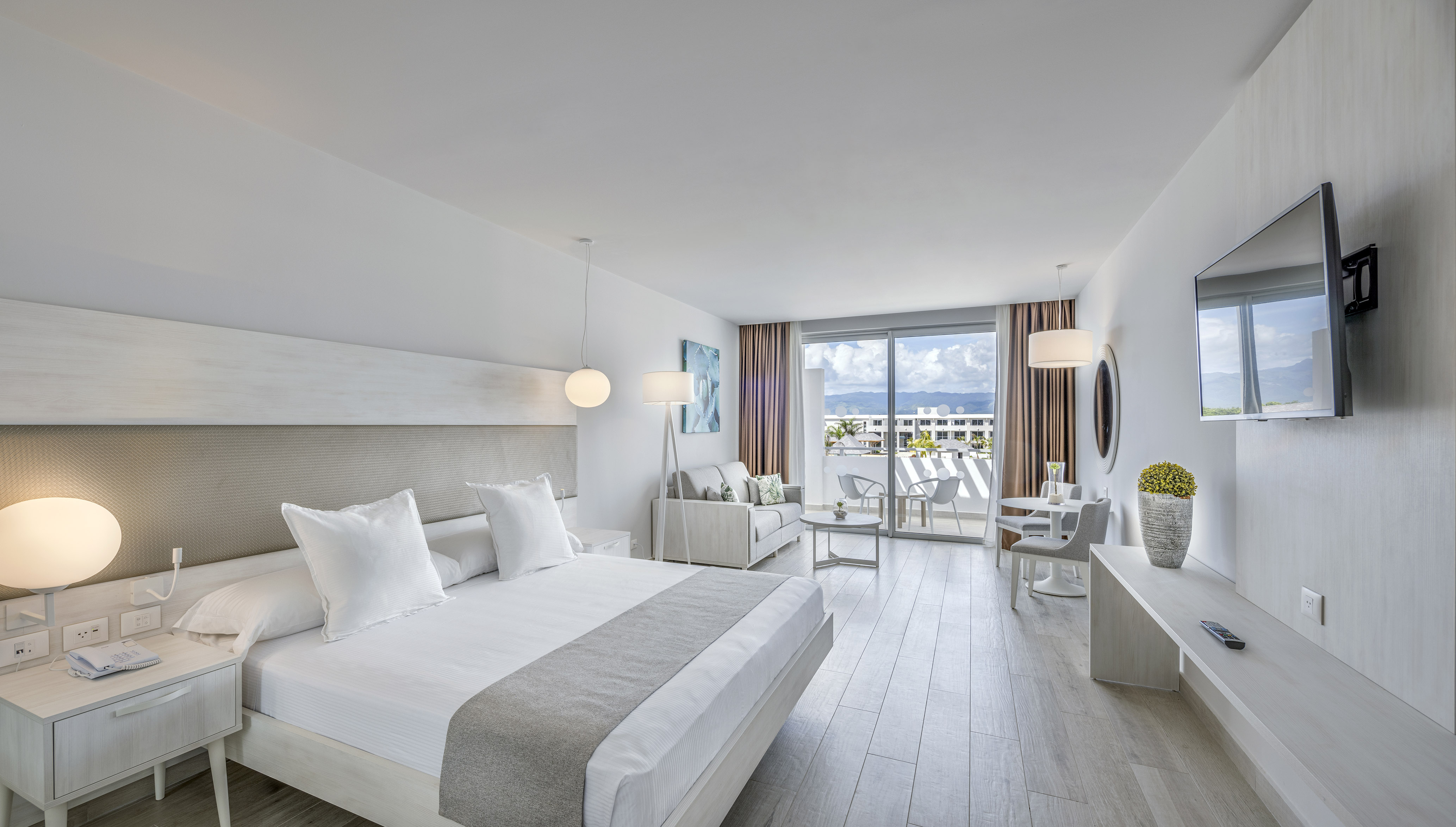 a bedroom with a large bed and a table and chairs