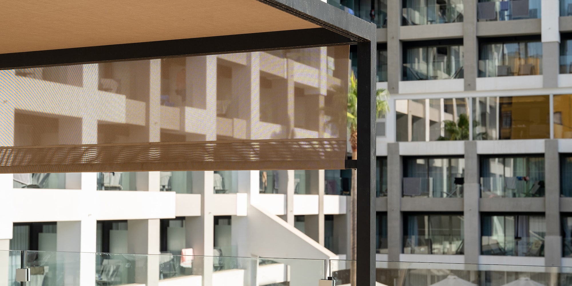 a table with a pool and a table with a drink and a building in the background
