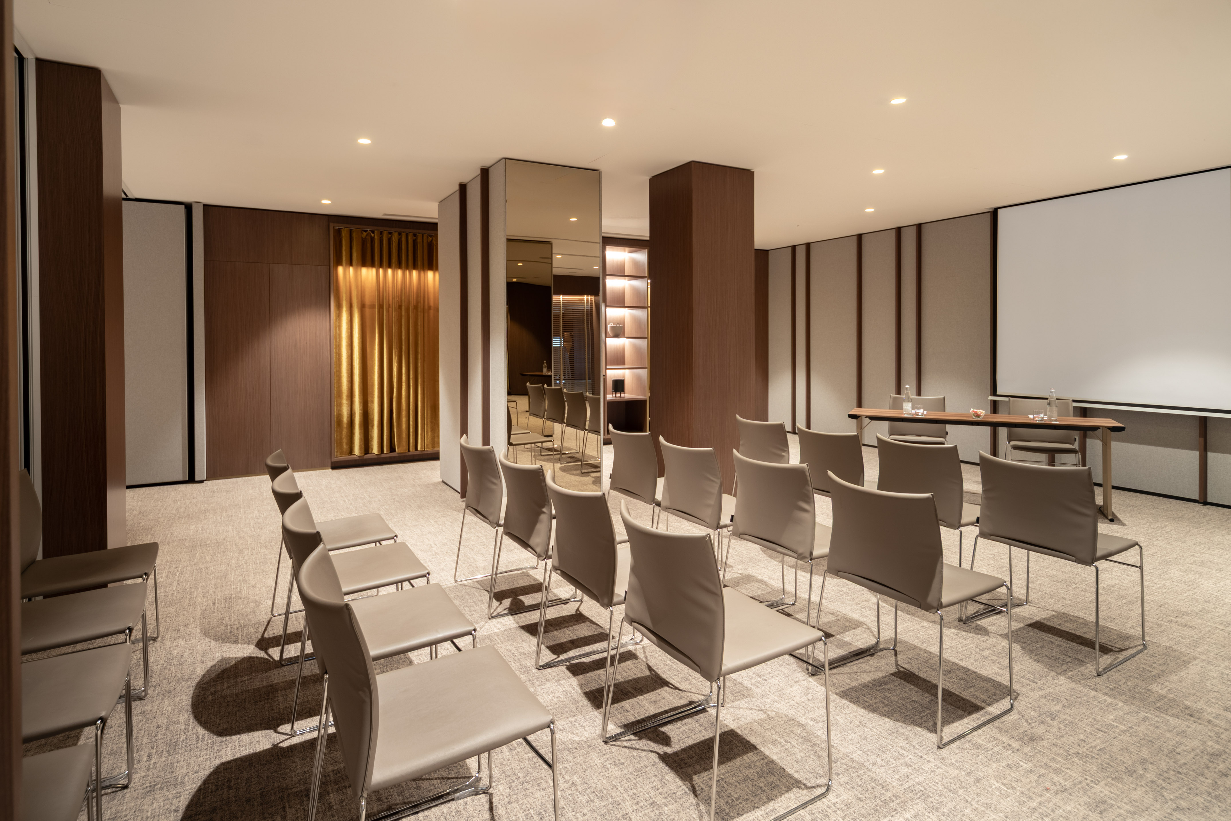 Empty modern conference room with chairs, presentation screen, wood accents.