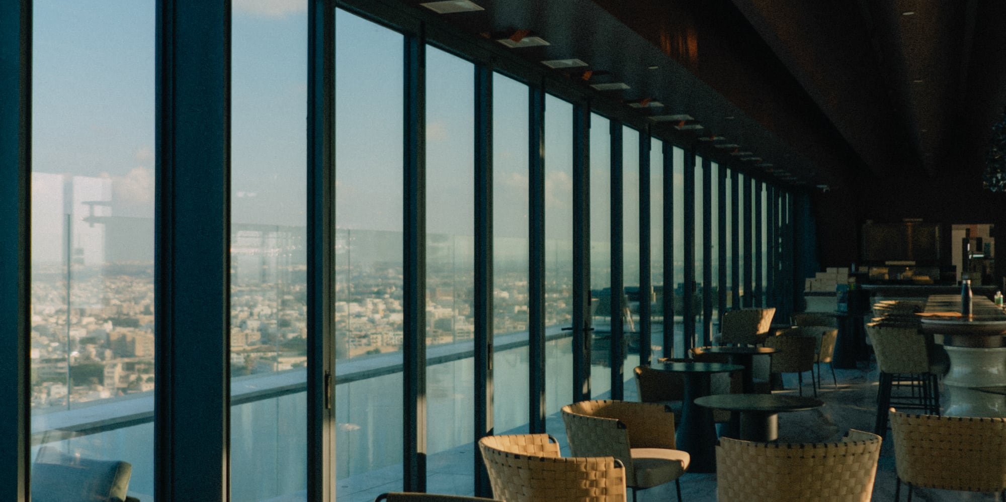 a room with tables and chairs and a view of a city