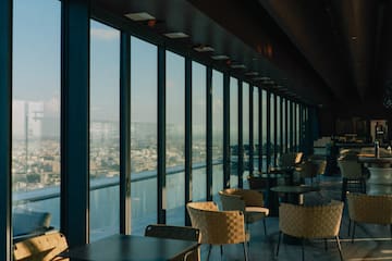 a room with tables and chairs and a view of a city
