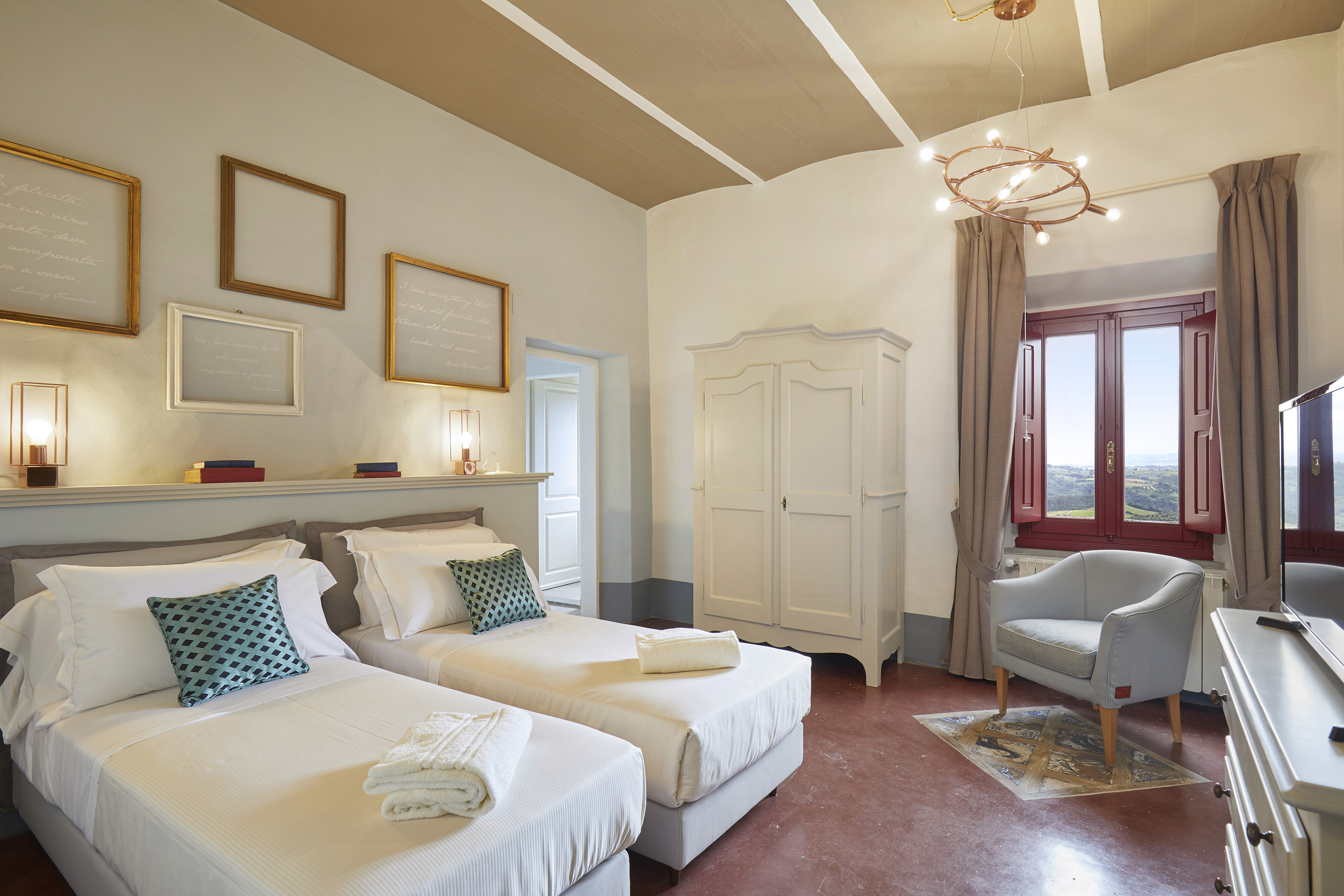 Rustic hotel room with twin beds, scenic window view, and classic decor.