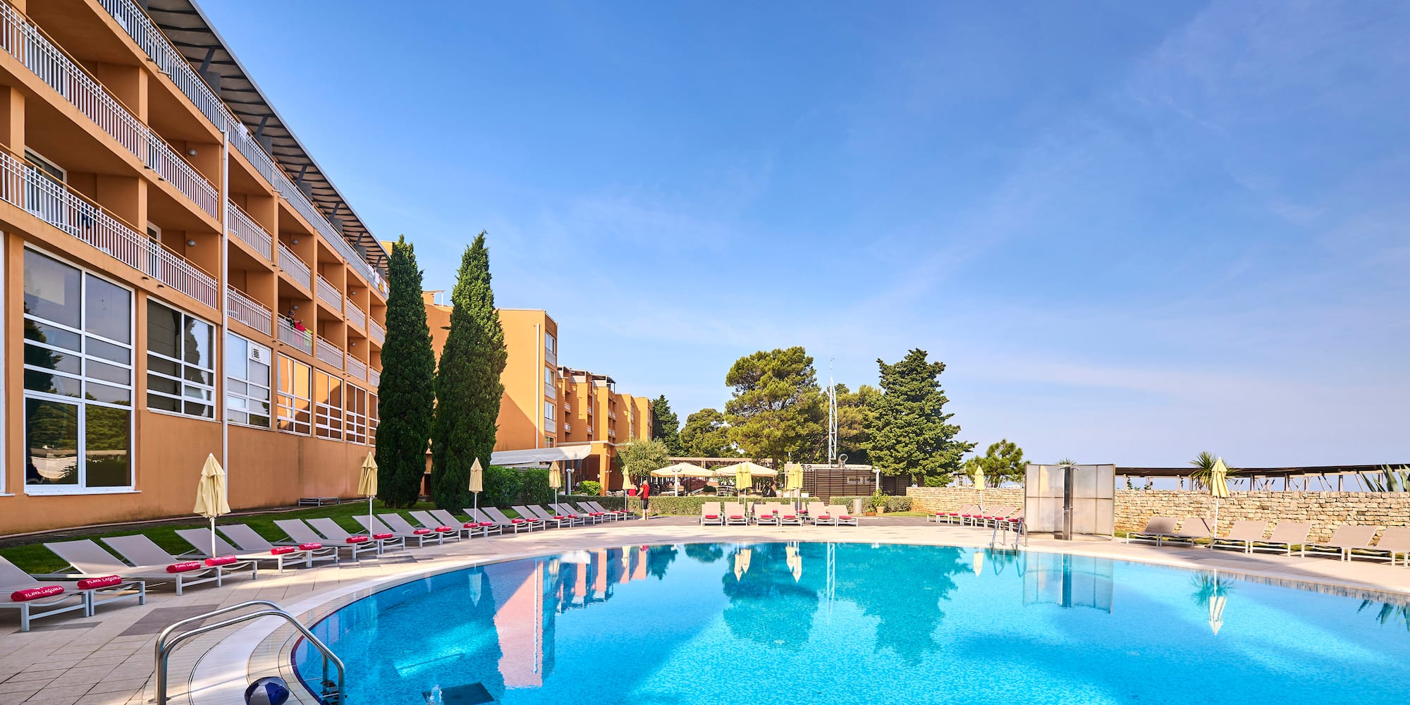 a pool with lounge chairs and a building