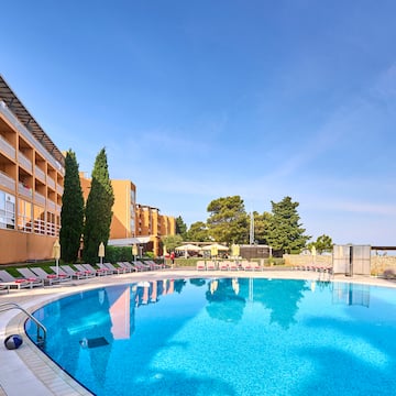 a pool with lounge chairs and a building