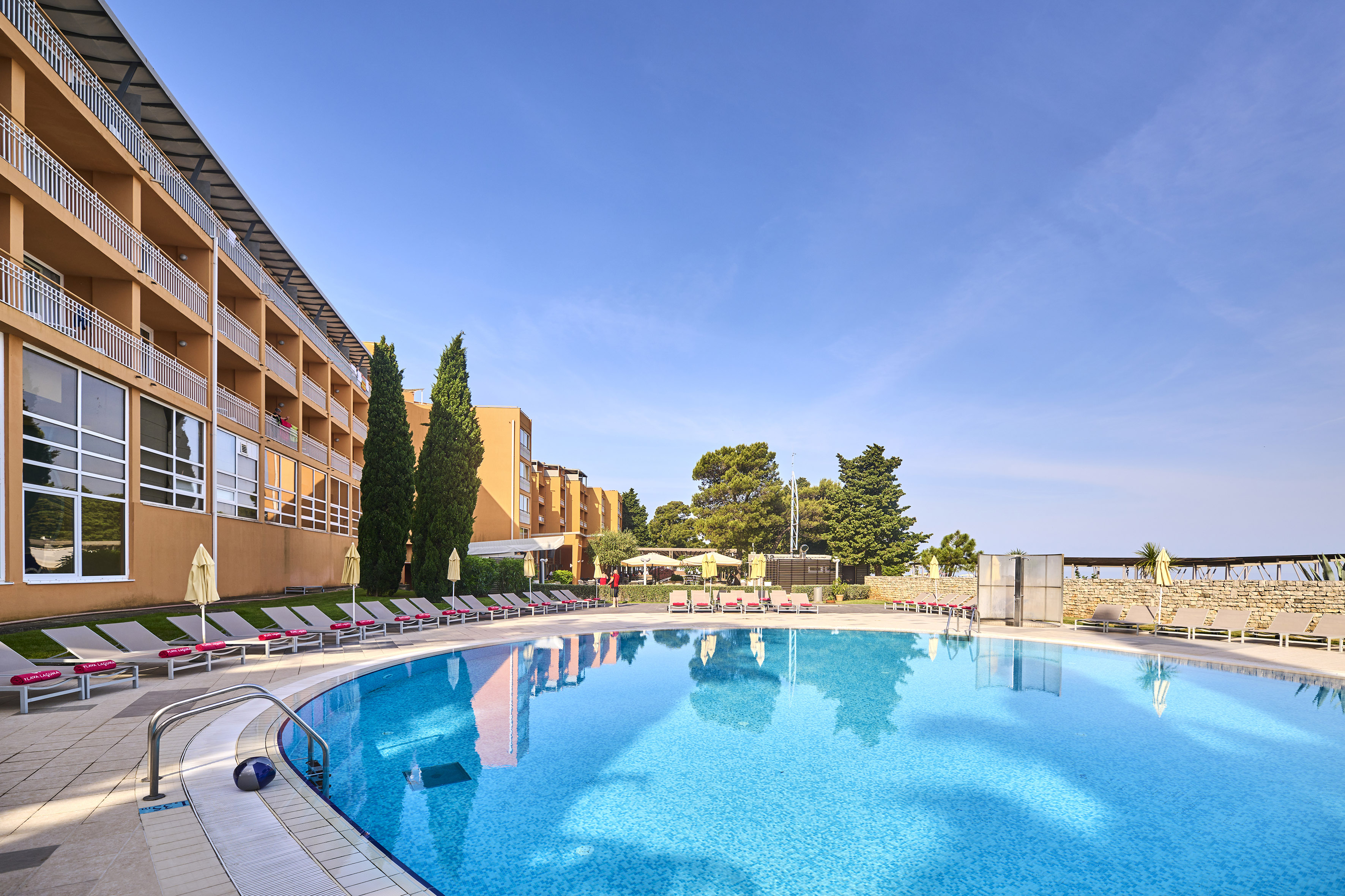 a pool with lounge chairs and a building