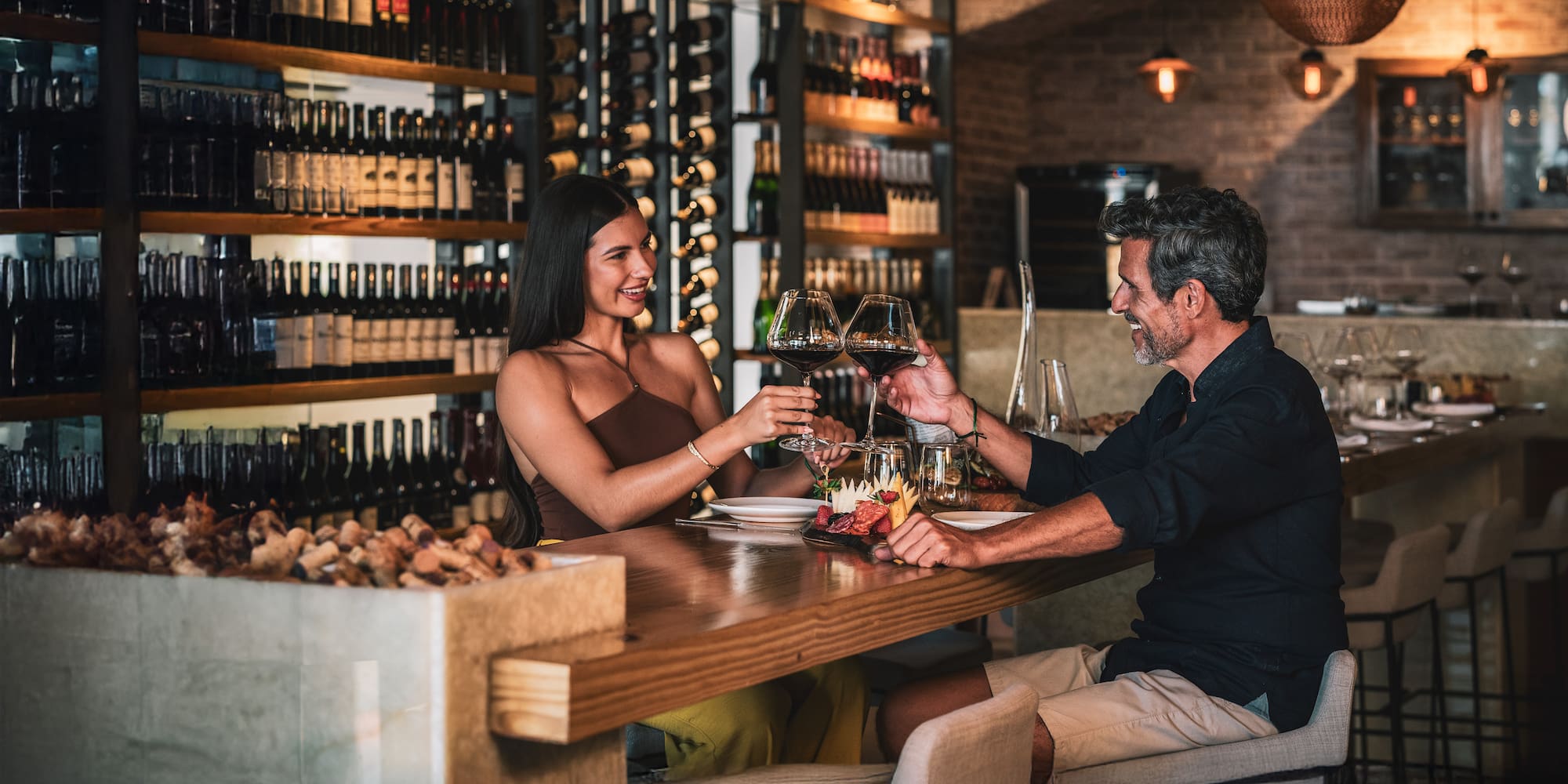 a man and woman sitting at a table with wine glasses