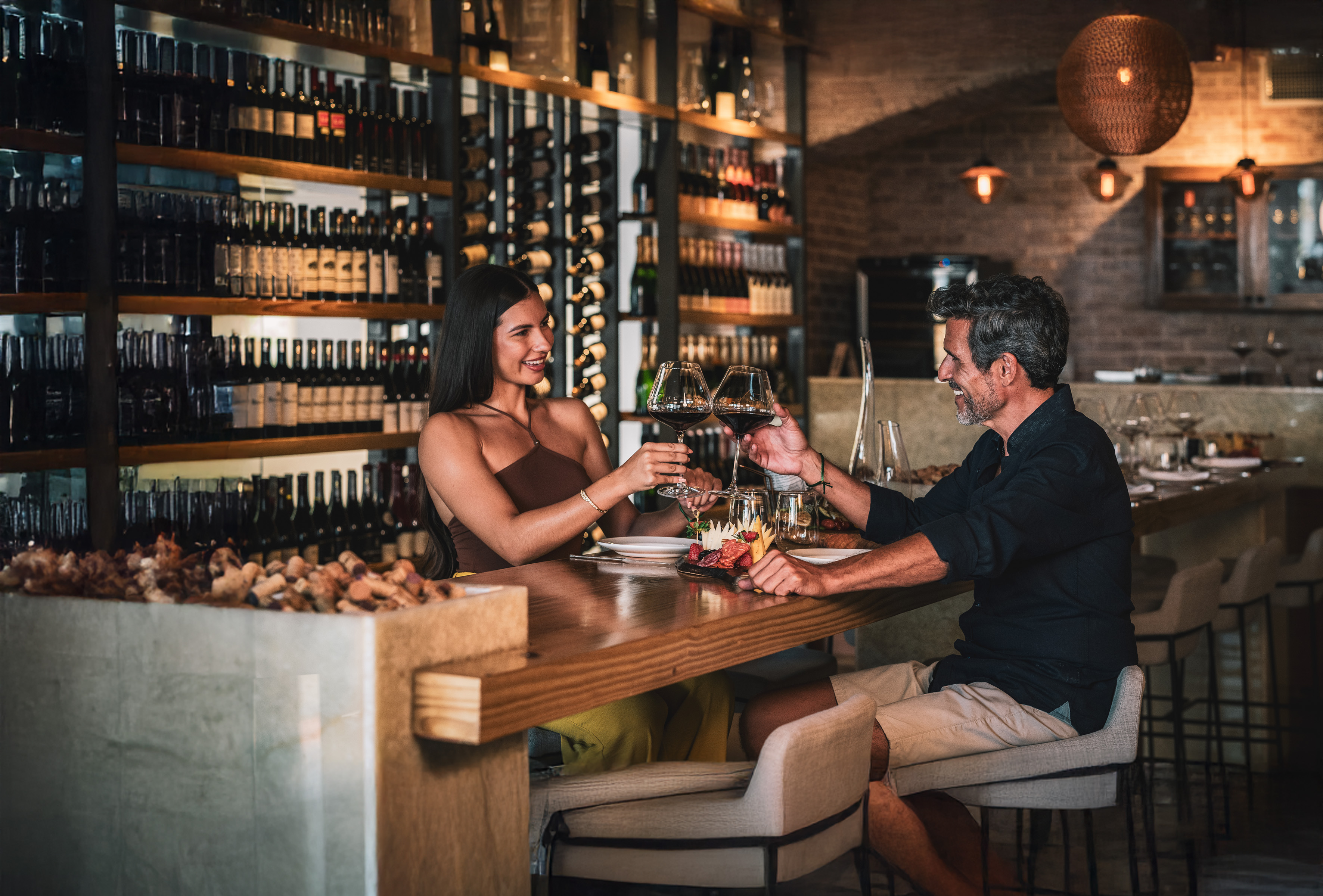 a man and woman sitting at a table with wine glasses