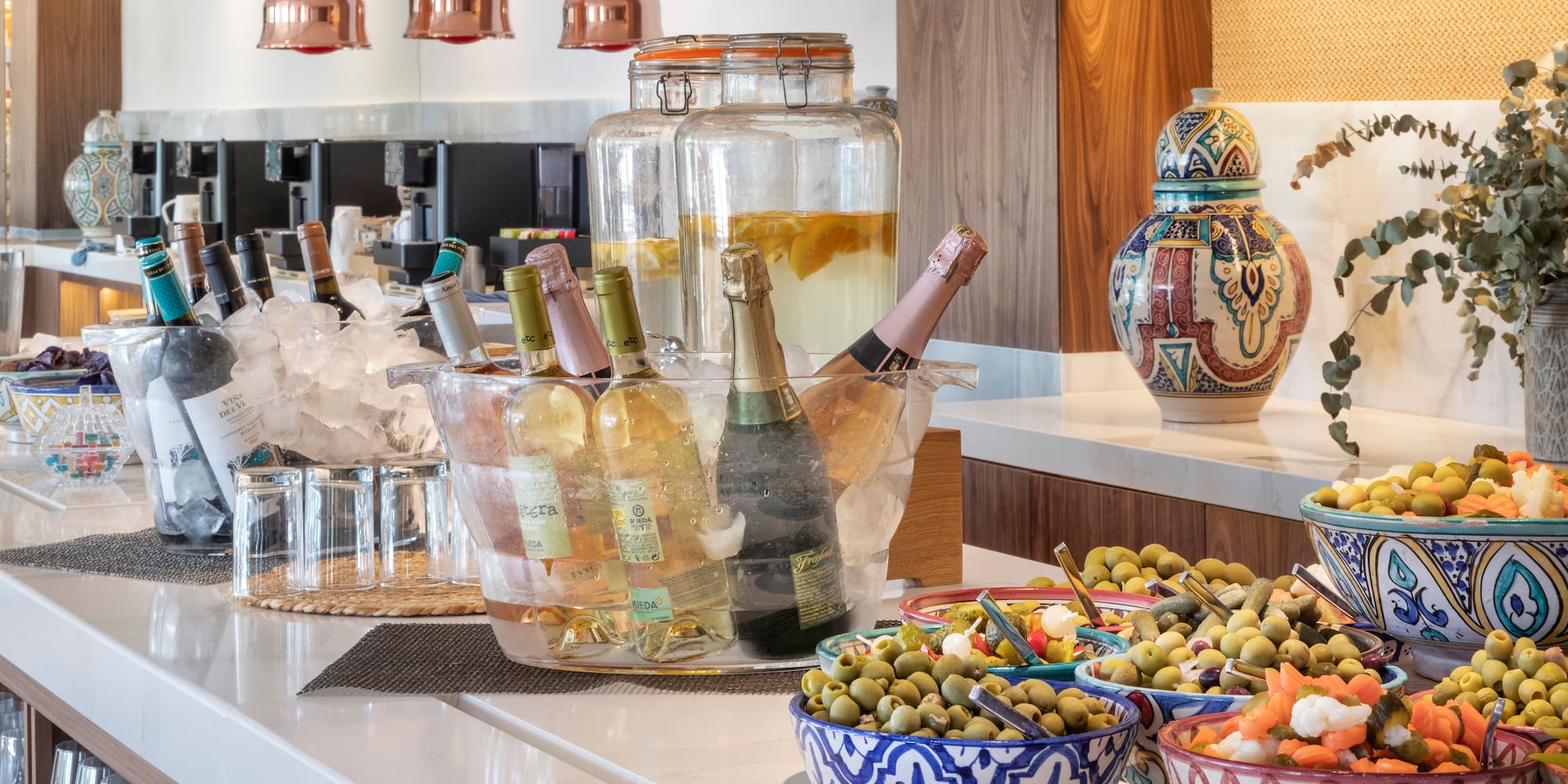 a buffet table with bottles of wine and food