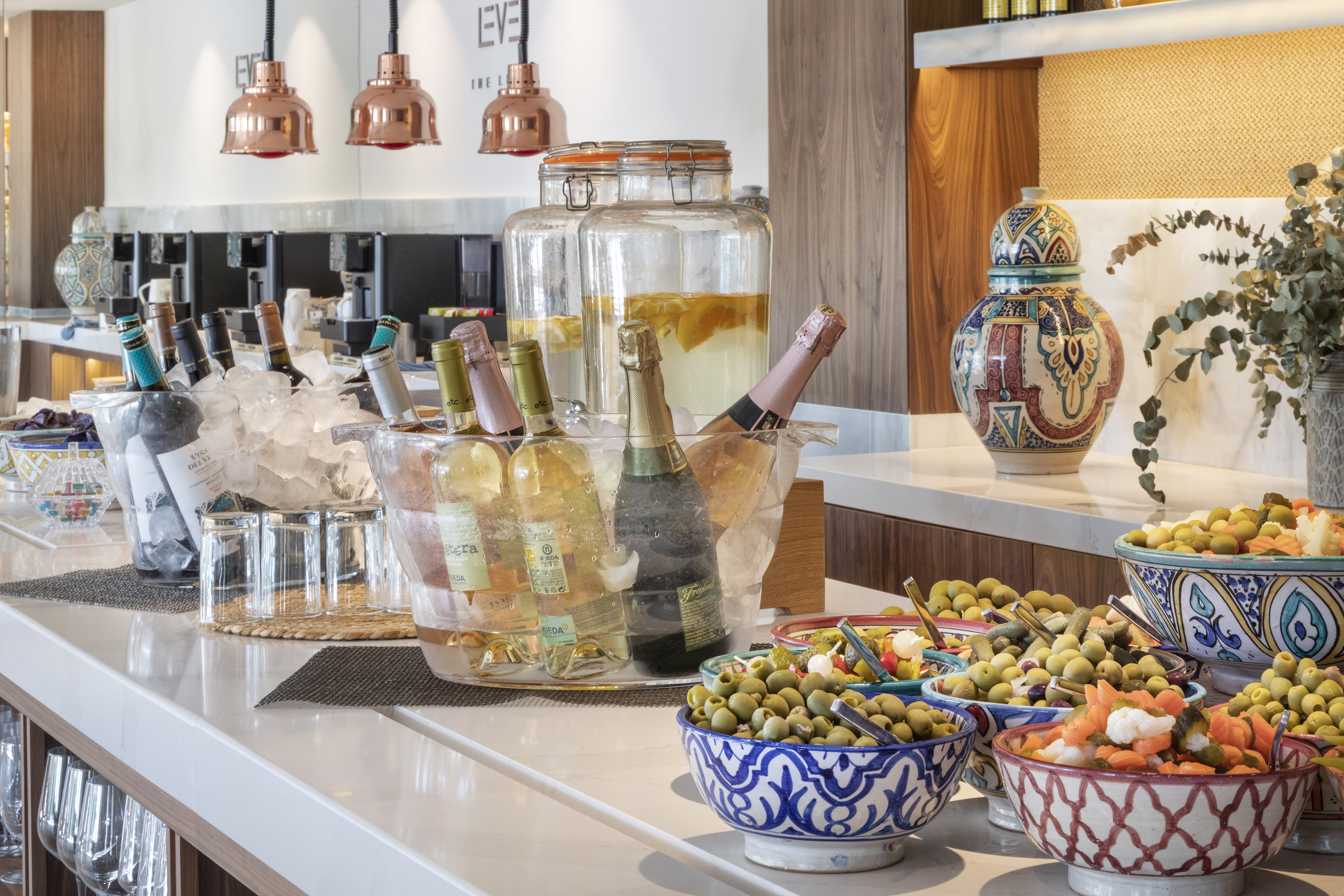 a buffet table with bottles of wine and food