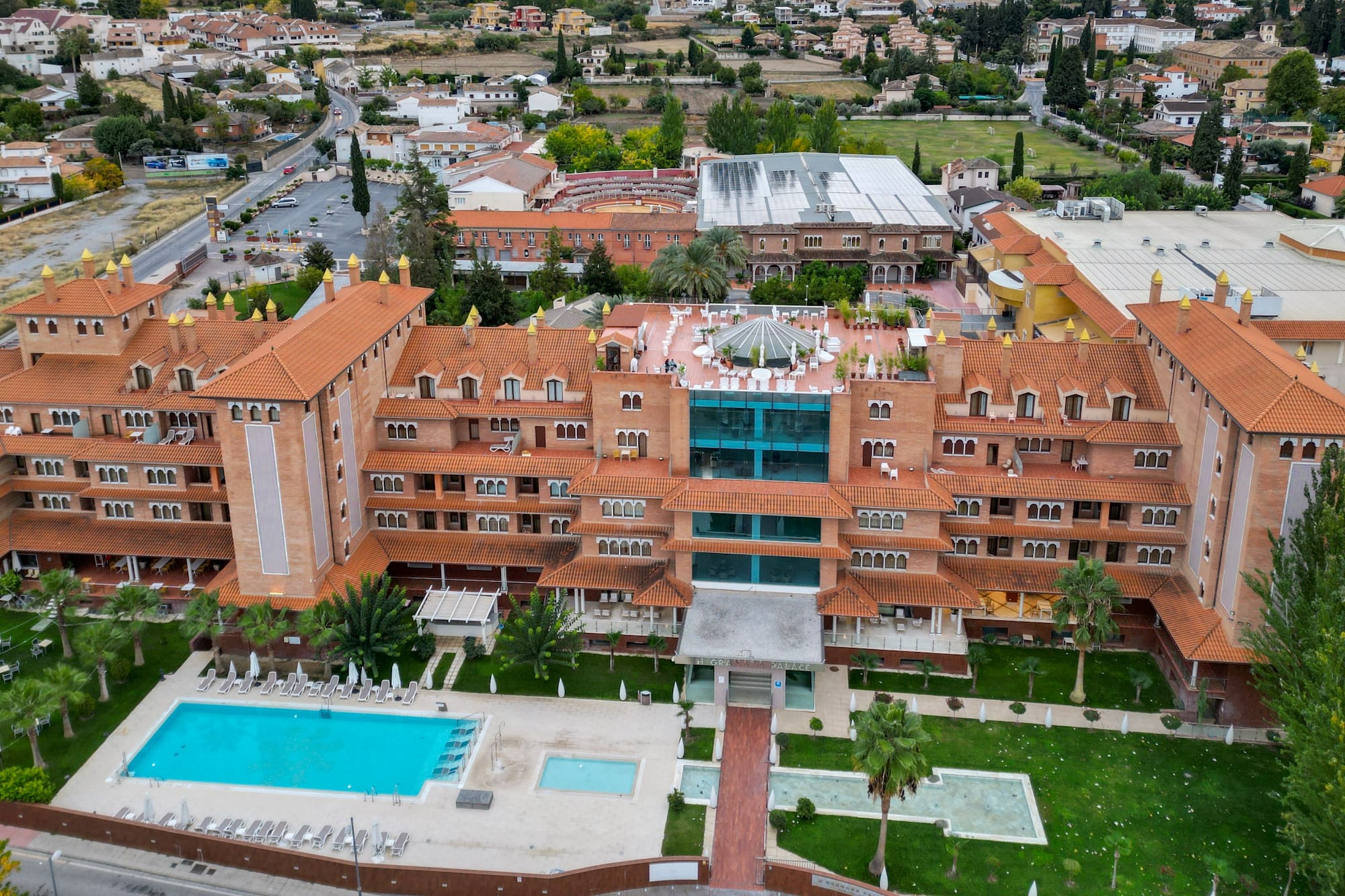 El Granada Palace luxury hotel, aerial view of red tile roof, pools, and city.