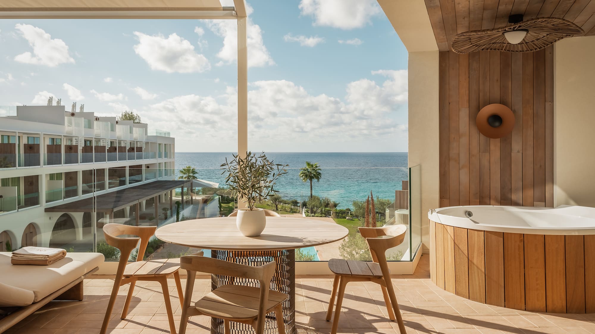 a patio with a hot tub and a table and chairs