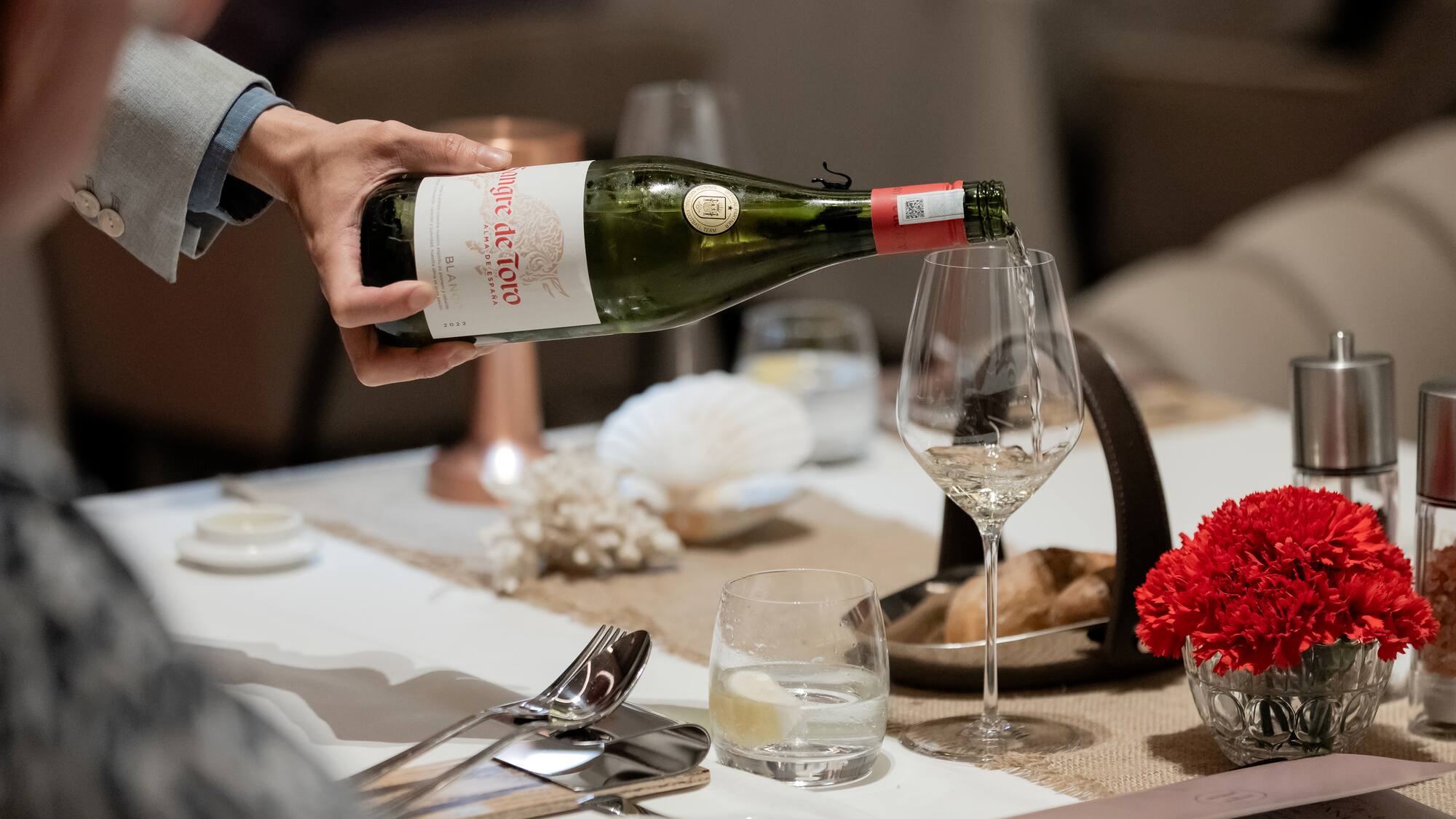 a person pouring a wine into a glass