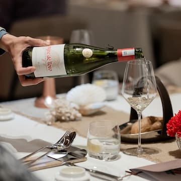 a person pouring a wine into a glass